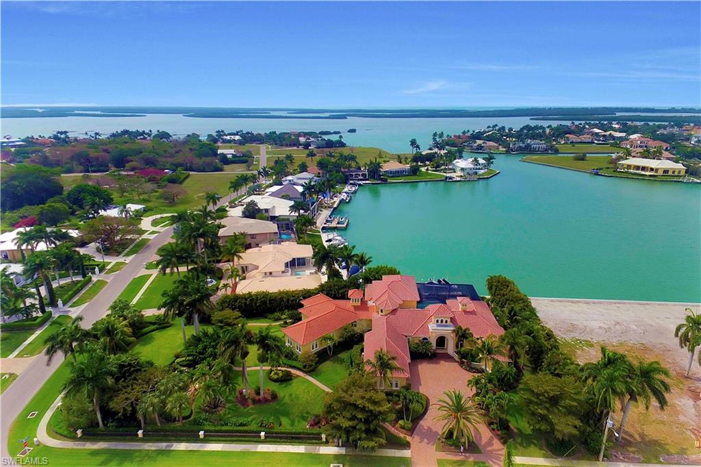 Welcome to this grandly scaled large estate home situated on one acre with 125 feet of water direct access providing breathtaking wide water views of Fredrick’s Bay. Capture the kind of elegance you’ve been looking for with a beautiful appointed formal dining and living room that includes a gas fireplace. A gorgeous gourmet kitchen with breakfast bar, gas stove, Sub-Zero refrigerator and custom cabinets blends harmoniously into the expansive family room with dining area. The master bedroom en suite includes a sitting area, two walk-in closets and gorgeous master bath with dual sinks, large walk-in shower, whirlpool tub and vanity. Adding to the grandeur are five large guest bedroom en suites, two of them with private balconies, a beautifully designed theater room, den, three wet bars, tray ceilings, built-ins, impact glass, and top quality designed finishes. A sweeping veranda with vanishing edge pool, oversized spa, pool bath and summer kitchen invites relaxation and open-air serenity. A large dock with 40,000-pound lift is perfect for the boater enthusiast. Surrounded by lavish tropical landscaping with a Zen garden, Kiow pond and pavered pathways. Start living in paradise today.