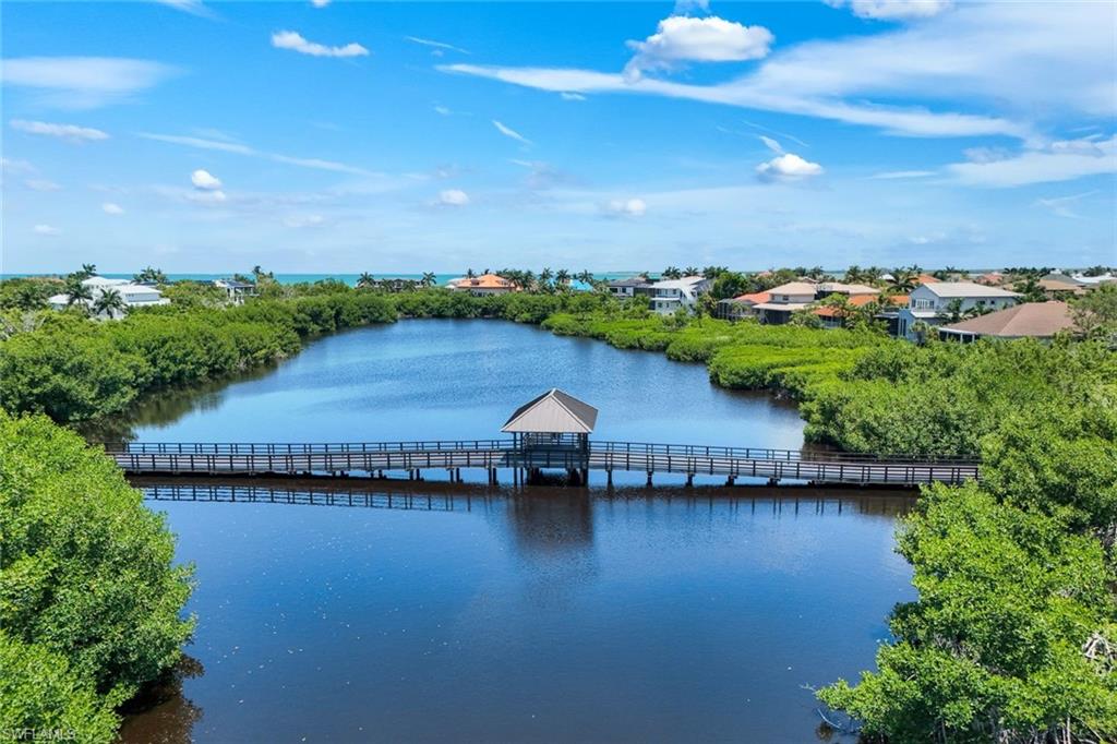 Experience the ultimate blend of coastal elegance, privacy, and resort-style living in this exceptional waterfront residence within the exclusive, gated enclave of Hideaway Beach. Perfectly positioned to capture spectacular sunset skies and tranquil waterway vistas, this remarkable home offers an extraordinary lifestyle unlike any other in Southwest Florida.

Thoughtfully designed across three spacious levels, the residence showcases refined craftsmanship & architectural detail throughout. Rich Brighton Plank maple flooring enhances the main living areas, while walls of floor-to-ceiling impact glass frame picturesque water views and fill the interiors with natural light. A striking hand-carved imported skylight serves as a dramatic focal point, adding warmth and character to the home's sophisticated design.
The chef's kitchen is both stylish & functional, featuring a gas cooktop, granite countertops, generous island seating, & a casual dining area overlooking the surrounding scenery. The adjacent living & dining spaces flow seamlessly to the screened lanai, creating an inviting indoor-outdoor environment ideal for entertaining. Detailed wood ceiling accents add a custom touch to this expansive outdoor retreat.

The second level offers comfortable accommodations for guests with two guest bedrooms, spacious living areas, and access to the lanai. Occupying the entire upper level, the private owner's suite serves as a luxurious sanctuary complete with a spacious bedroom, spa-inspired bath, and an adjoining family room & den that can easily function as a media room &/or additional bedroom(s). A private balcony provides the perfect setting to enjoy peaceful mornings, breathtaking sunsets, & stunning water views.
Convenience & functionality abound with elevator access to every floor, from the garage level to the upper retreat. Designed with the automotive enthusiast in mind, the oversized garage currently accommodates multiple vehicles plus a golf cart garage, workshop area, fitness room, & now a Speakeasy-vibe room w/ a wine room.
Built to exacting standards, the home incorporates reinforced concrete floors, walls, and roof, impact-resistant windows & doors, and a 20KW Guardian generator, providing exceptional structural integrity & peace of mind. 
Ownership includes access to the incomparable Hideaway Beach lifestyle offering one of the most comprehensive amenity packages. Just moments away, residents enjoy a private beachfront club with Gulf-front dining, a pool, social venues, and direct access to miles of sugar-sand beach. The newly built, state-of-the-art Sports Centre offers a 9-hole executive golf course, golf simulators, exercise classes, pro shop, & fitness room. Hideaway Beach boasts one of the few stunning private beachfront clubs (updated in recent years).  Also available is tennis, pickleball, & bocce. A rare opportunity to enjoy luxury living in one of Southwest Florida's most prestigious private coastal communities.