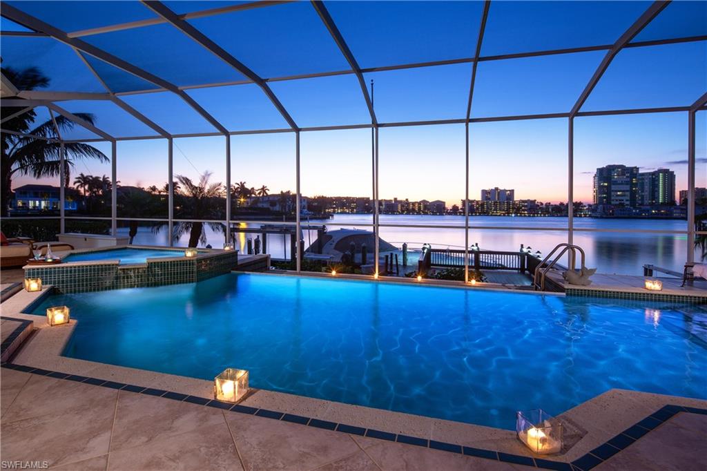 Long, wide water bay views are the focal point of this sprawling one-level home on Moorings Bay.  Featuring sought after western exposure, over 100 ft of waterfrontage and an expansive outdoor area with both covered and uncovered spaces, the sunsets here cannot be beat.  Copious amounts of glass along the back of the property provide a light and airy feel while providing views from nearly every room.  Open kitchen, spacious master suite and high ceilings make this an ideal place to enjoy the Naples waterfront lifestyle.  Located just a short stroll from shopping and dining in the Venetian Village. Moorings residents have the ability to join the Moorings Beach park which is only a short bike ride away. Digitally Remodeled Exterior Photos in MLS Photos, in permit for depicted remodel but would need to commit soon.
