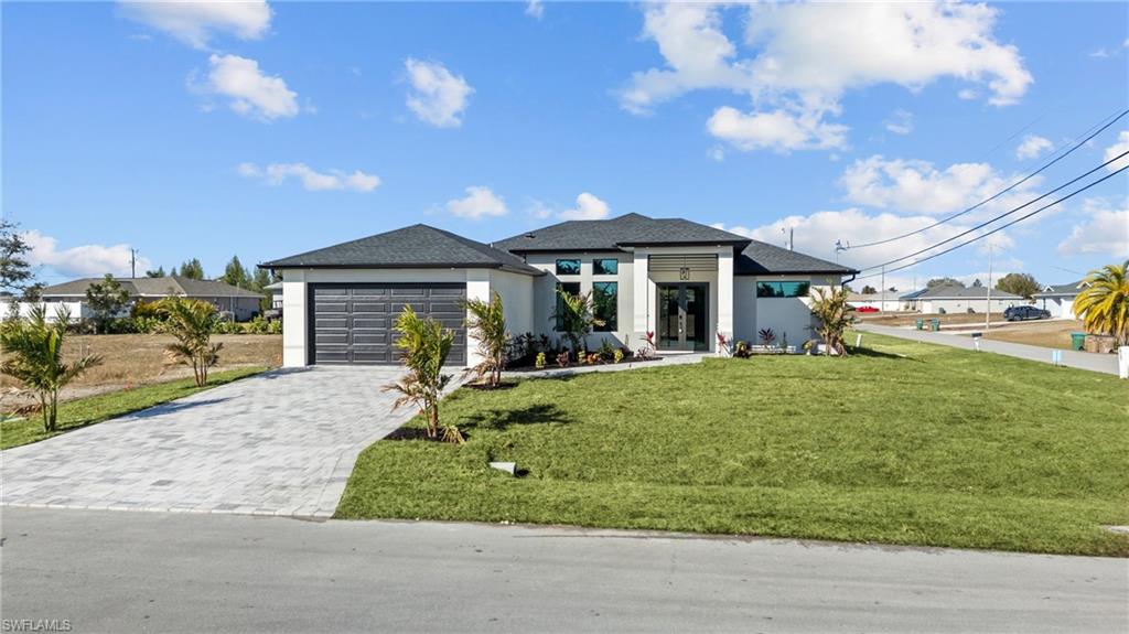 Welcome to this stunning NEW CONSTRUCTION beauty in Cape Coral, sitting on a CORNER LOT and offering over 1,700 sq. ft. of modern luxury with 3 bedrooms and 3 full bathrooms—including a highly desirable pool bath, perfect for when you add your dream pool. From the moment you walk in, you’ll feel how meticulously this home was designed. The tall ceilings with tray LED lighting, and sleek open layout create a bright, airy feel that’s perfect for entertaining. The split floor plan gives everyone their own space and privacy—while still keeping the home open and connected. The kitchen is a showstopper: spacious, modern, and built for real living, featuring a STYLISH BACKSPLASH, SOFT-CLOSE CABINETS, SLEEK STAINLESS STEEL APPLIANCES including built-in MICROWAVE/OVER COMBO and a HOT WATER POT FILLER/WARMER for luxurious convenience. The best features of the home: IMPACT DOORS & WINDOWS, GUTTERS with FASCIA/SOFFIT detailing throughout, MODERN TILE throughout the entire home, Beautiful modern LED LIGHTING details, CONTEMPORARY CHANDELIERS and PRE-WIRED MEDIA WALL, HIS & HERS CLOSETS in the Owner's Suite including FLOOR-TO-CEILING TILE and GLASS ENCLOSURES for a true spa-like feel, Finished landscaping for curb appeal from day one, EPOXY FLOORING in the garage for that clean, finished look. Plus, there’s already a CONNECTION in place for an EXTERIOR KITCHEN, making it easy to create the ultimate backyard entertaining setup. And the best part? This home is on CITY WATER, SEWER & IRRIGATION—so you don’t have to deal with septic and salt systems. The house it located in a NO FLOOD ZONE, which is a huge win for peace of mind and insurance. The home has been virtually staged to help you picture the lifestyle. 1 YEAR BUILDER WARRANTY INCLUDED. Some of the photos are virtually staged. Schedule your showing today!