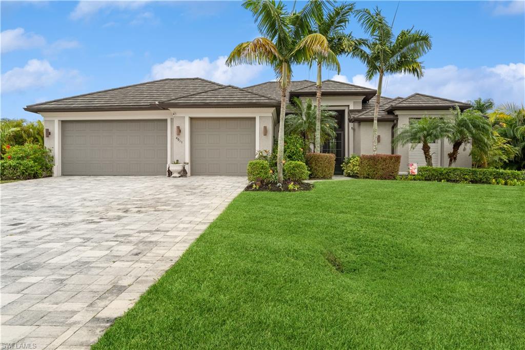 Major price improvement on this lovely SW Cape Coral home on an OVERSIZED TRIPLE LOT with so many incredible features both inside & out! Stately Royal Palm trees & lush tropical foliage greets you at this large home site as you approach the entrance. Double doors welcome you  into the open great room to experience the view through huge 10 ft. pocket sliding doors out to your tropical oasis on the lanai with heated pool & spa and full outdoor kitchen which includes new built in BBQ grill, wine fridge, built in ice maker, sink with disposal & granite counters.  Beautiful palms and tropical foliage make this back yard your private oasis for wonderful outdoor living.  A new stone coated steel metal roof plus solar attic fan installed in 2023, newly screened lanai in 2023, high impact resistant PGT windows and doors, new A/C in 2020, custom window coverings, whole house water filtration system, automatic sprinkler system and more will make this home a dream to own....There's nothing to do but move in and enjoy!   Central water, sewer and irrigation system are in and assessments are PAID IN FULL.   Ask for a copy of the complete feature sheet & schedule your private showing today!