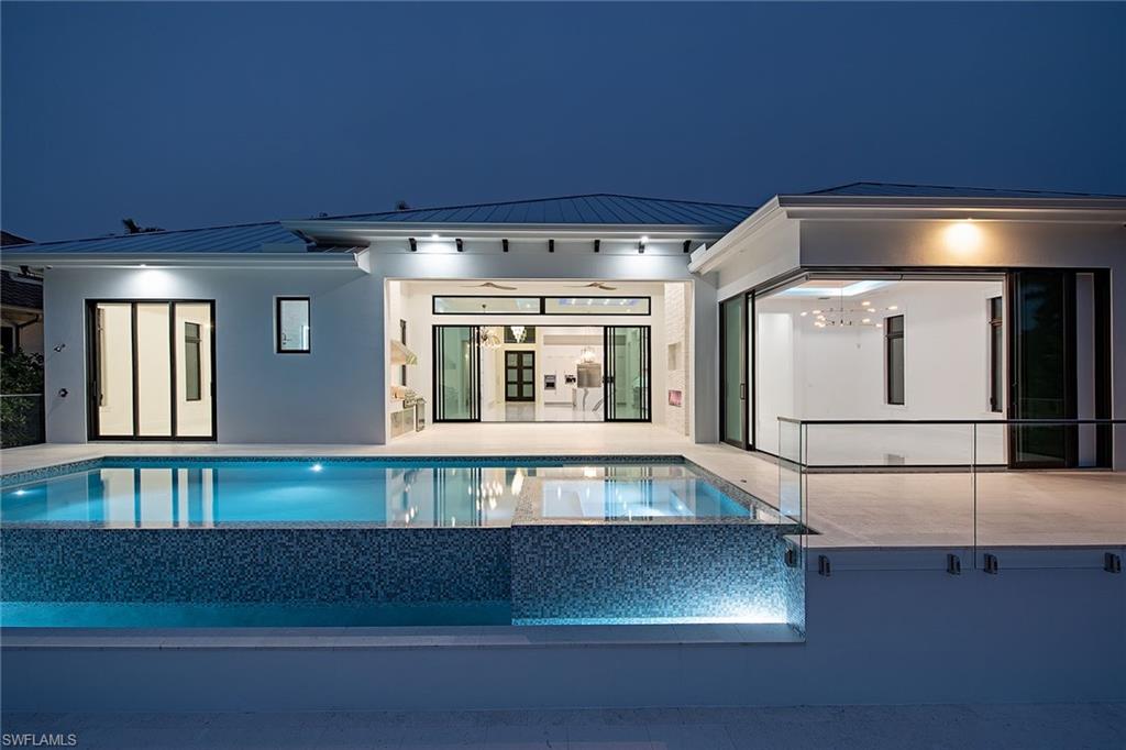 New construction. Discover luxurious living at this one-of-a-kind, waterfront residence complete with a boat dock with lift and resort-style, infinity-edge pool and spa. The impressive four-bedroom, four-and-one-half-bathroom residence features over 3,000 square feet of living space. The gourmet chef’s kitchen features top-of-the-line appliances, including a six-burner gas range, free-standing ice maker, beverage center drawers, built-in coffee station and an integrated wine center. The master retreat features a contemporary walk-in shower, free-standing soaking tub, dual sinks and dual walk-in closets. Modern design and décor can be found throughout the home showcasing gorgeous quartz countertops, elegant fixtures, pocketing sliders and indoor and outdoor fireplaces. The residence is completed with an outdoor living area, outdoor kitchen with gas grill and a three-car garage with the ability to accommodate six vehicles with the use of a car lift. All ideally located just minutes from Naples' fine dining, world-class shopping and gorgeous white sand beaches.