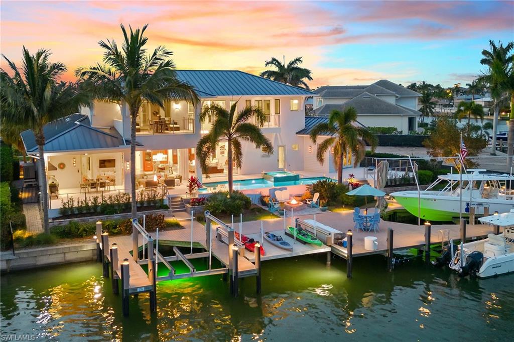 This impressive MHK-designed home boasts an unparalleled 130 feet of direct access waterfront living with 100-foot dock featuring 30K, 9K and 6K lifts, and new fire pit. As you enter the 4-bedroom, 5-bath highly upgraded residence through dramatic 10-foot mahogany doors, you are greeted with soaring ceilings, expansive 2-story bay views, wide plank French oak floors, designer lighting, impact glass and plantation shutters. Expansive open living area perfectly blends indoor-outdoor living. Gourmet kitchen provides premium appliances, gas cooking, book-matched walnut cabinetry, quartz and granite counters, and walk-in pantry. The outdoor space offers SE exposure, cedar ceiling, shell stone floors, outdoor kitchen, electric screens and shutters, and gas and electric-heated 39-foot saltwater pool and spa. The master suite is impressive with a vaulted ceiling, spa-like en suite, and large walk-in closet with built-ins. Upstairs you will find guest suites and a balcony overlooking the bay. Enjoy quick boating access, Control4 automation, surround sound, video security, whole-home generator, wine refrigerator, elevator, and a 3-car garage with room for car lift. Immaculately maintained.