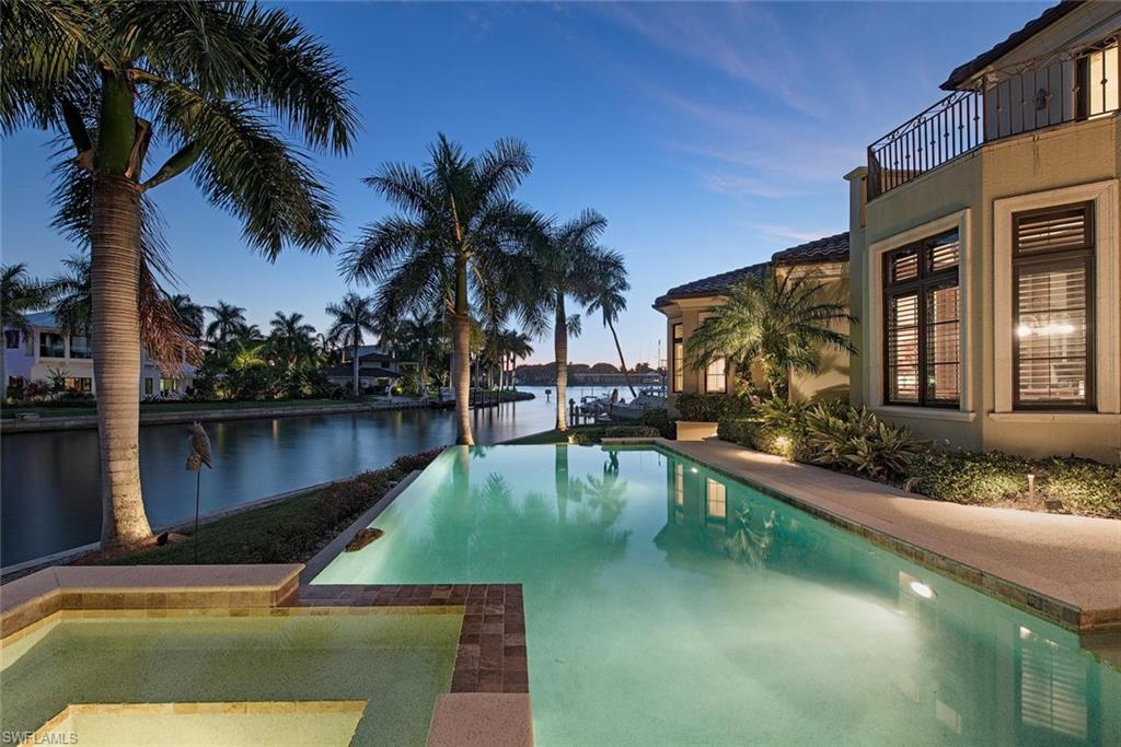 H.10055  Magnificent, customized dream home just feet from Naples Bay with 259 feet of water frontage!  Residence is immaculate and features, over-sized bedrooms with en-suite baths, multiple living areas, gourmet kitchen with top of the line appliances, whole house integrated lighting system, 4-zone HVAC system, 4-car garage, formal dining room, living room with fireplace, majestic entry with open staircase, wet bar, multiple balconies and more!  Home has southern exposure and is an entertainer's dream with expansive outdoor living area, outdoor kitchen, large infinity pool/spa, and boat dock with lift. Ideally located on wide, intersecting canals just feet from Naples Bay!