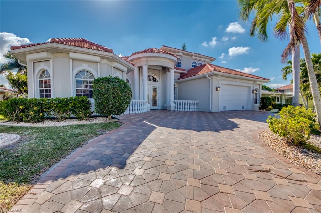 Must See... Big and Beautiful 2-story SW Cape Coral Pool Home with Direct Access just 2 minutes from Open Water and No Bridges.   The Circular Paved Driveway leads to a Glass Double Door Entry and Custom Tile Foyer with Italian Columns leading to a Huge Open Concept Home with Amazing Waterfront & Pool Views from just about everywhere.   3 Full Bedrooms Downstairs including an Awesome Master Suite with Walk Thru Shower, Office Space, and Sliding Door to Lanai.  The Custom Coffered Ceilings, & Central Vac System are just some of the many features.  The Open Kitchen Concept features a Huge Kitchen Table, Bar area, and access to the Formal Dining area.   All of which have views of the Water!  Upstairs is another HUGE Master Suite, and a 5th Bedroom along with a Loft Seating Area.  The 2nd Floor Lanai is Open, and has incredible Views of the Caloosahatchee River. 
There is Tons of storage here as well.   The Outdoor Oasis is simply amazing with a Large Heated Pool and Spa, Outdoor Shower, 1/2 Bath, and Large Dock, with Captains Walk and Canopy covering the Boat Lift.  A New Tile Roof was installed in 2018 & there are Electric Hurricane Shutters on Every Window in this Home!