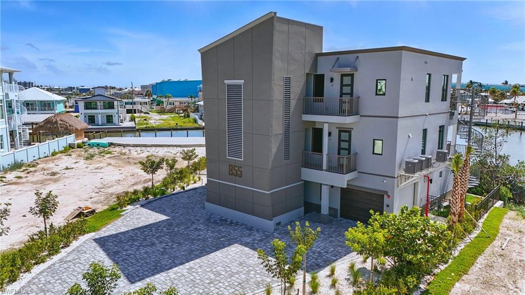 One or more photo(s) has been virtually staged, AI generated or rendered.  Built to Commercial Code, brand-new 2 bed/2 bath gulf-access condo on Fort Myers Beach’s coveted North End with private boat slip, rare enclosed garage, and direct Gulf access—just about 400 ft from the sand. 855 Lagoon Street was built with high-performance SIP construction, serious hurricane engineering, a new poured-concrete seawall, and easy-care tropical landscaping, so you can spend more time on the water and less on maintenance. Inside, you get a bright open layout, stylish tilework, modern cabinetry, generous bedrooms, and timeless but modern finishes. Your slip is just outside—reach the Gulf in roughly 10 minutes—or relax at the community pool, then walk to Margaritaville, Times Square, Bowditch Park, dining, shops, and the new Whale. If you’ve been holding out for a North End new-construction waterfront condo that truly checks the boxes, this is the one.