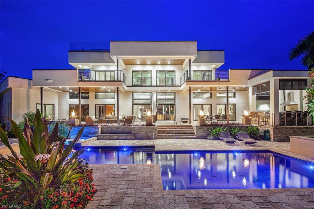 H.14829 Luxurious. Elegant. Exceptional.  European style & design blend together beautifully in this Southwest facing waterfront tropical estate on a nearly half ac. lot w/ 164’ of water frontage & Gulf access. Clean contemporary lines & luxurious finishes are accented by walls of glass & gorgeous views.  Featuring an open floor plan w/ sleek kitchen & unique finishes such as Brazilian rosewood, linear eco-friendly fire feature, & custom steel & glass floating stairs & walnut flooring.  Zen-like master suite w/ sitting room & dressing room, plus indoor/outdoor garden shower & Japanese Aioki wood soaking tub.  An addtl. ground floor guest suite allows flexible accommodation. Upstairs living room w/ wet bar & 4 more bedrooms all with SW water views, & spacious balcony.  There’s also a rooftop viewing balcony w/ Gulf views.  Stunning outdoor area that rivals any 5 star resort, & includes a pool w/ cascading water feature, spa, terraced verandas & outdoor kitchen pavilion.  A water enthusiasts dream, with 80’ dock, 2 separate boat lifts, plus jet ski lift. Live the ultimate tropical lifestyle, surrounded by flowering trees & swaying palms steps to the beach & downtown Naples.