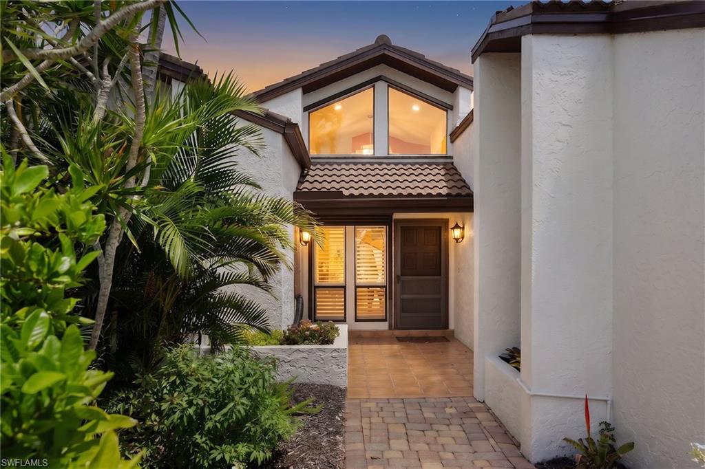 Beyond the gates of a private enclave, this extensively renovated lakefront residence unfolds as a seamless blend of contemporary design and effortless Southwest Florida living. Reimagined in 2023, with a new roof completed in 2022, the home is thoughtfully on an expansive homesite where panoramic water views and a sense of privacy define the setting. A cathedral foyer welcomes you inside, where large-format tile flooring, custom wood detailing and recessed lighting create a refined backdrop for everyday living. The home's open layout naturally draws attention toward the water, with sightlines extending through the main living spaces to the expansive heated pool, spa and lake beyond. At the heart of the residence, the sunken living room is framed by cathedral ceilings, a wood-burning fireplace and walls of glass that invite natural light indoors while showcasing the property's tranquil waterfront setting. Nearby, the redesigned kitchen combines style and function with quartz countertops, shaker-style cabinetry, stainless steel appliances, designer tile accents, a spacious walk-in pantry and thoughtfully integrated lighting. The primary suite serves as a private retreat, offering dual walk-in closets and a spa-inspired bath appointed with an oversized frameless-glass shower, mosaic tile flooring and a glass-block feature wall that fills the space with natural light. Throughout the home, thoughtfully updated baths, custom cabinetry, quartz surfaces and a redesigned laundry room reflect the same attention to detail found in every renovation. Outdoor living is equally inviting. A resurfaced heated pool and spa anchor the expansive pool deck and covered lanai, creating multiple spaces for gathering, dining or relaxing. A private walled courtyard provides additional flexibility for pets, gardening or enjoying a quiet morning outdoors, while mature subtropical landscaping enhances the property's sense of seclusion. Every detail has been considered for comfort and efficiency, including three independent climate zones, coastal-rated exterior lighting, updated fixtures and upgraded ventilation systems. Just 3 miles from Gulf beaches and approximately 25 minutes from Southwest Florida International Airport, the residence also enjoys convenient access to Spanish Wells Country Club, where optional membership offers 27 holes of golf, tennis, pickleball, bocce, fitness programs and resort-style amenities. Offering lakefront views, extensive renovations and proximity to some of Southwest Florida's sought-after coastal destinations, this move-in-ready residence presents an exceptional opportunity to enjoy a lifestyle defined by comfort, convenience and connection to the water. Membership is optional.