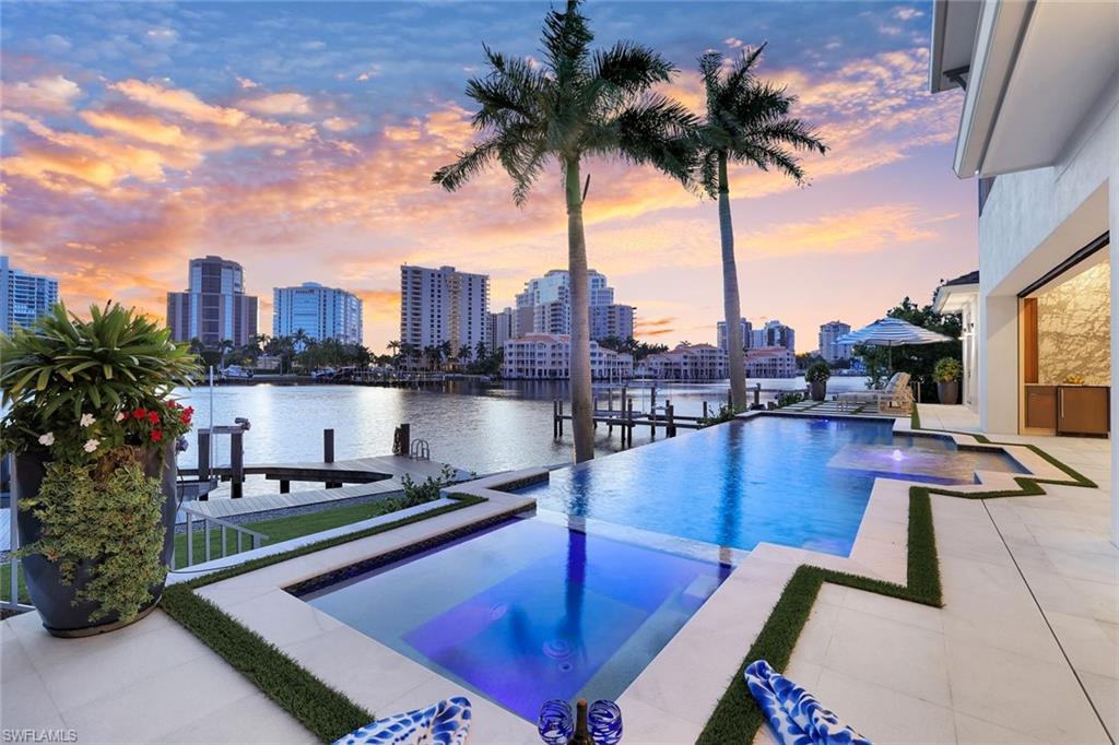 Refreshed with many updates in Summer 2025, this 2023-built waterfront residence blends modern sophistication with timeless design in the heart of Park Shore. Located on quiet Neapolitan Way, within walking distance to the beach and the dining and boutiques of Venetian Village, this property has 104' of water frontage on Venetian Bay.  Elegance, comfort, and convenience: Sparkling chandeliers, intricate tile work, and expansive 4-by-4 foot marble slabs, complemented by warm European oak flooring, create a radiant and refined interior.  A private elevator services all levels (including garage), and two beautiful outdoor spaces — a covered lanai and an upper-level balcony — offer ideal vantage points for enjoying iconic Naples sunsets.  The kitchen features Thermador appliances, Calcutta gold countertops, Brazilian cherrywood accents, and a new marble backsplash, while a temperature-controlled wine vault holds up to 500 bottles. Thoughtful floorplan design allows for all guest rooms to have perfect privacy and views. Four of the five bedrooms showcase sweeping views of Venetian Bay, where you can watch boats come and go throughout the day — adding movement, beauty, and a true sense of waterfront living. Step outside to your private bayfront retreat, complete with a negative-edge saltwater pool, spa, outdoor kitchen, and fireplace. The private dock accommodates boats up to 44 feet — quintessential for embracing the Naples waterfront lifestyle. Recent updates include a sleek glass railing around the pool deck, a brand new 28KW generator, fresh interior paint, and a striking imported Italian porcelain accent wall in the two story great room. Click on the virtual tour link for a video of this home, it is truly stunning. Living Level is at 12' NAVD. Seller financing available.