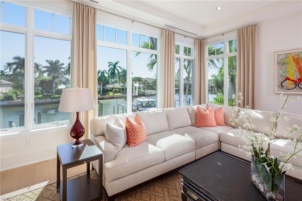 Beach. Boating. Bliss. Spectacular residence at Naples Casamore furnished by Godfrey Design with panoramic views overlooking Hurricane Harbor. Sophisticated entry, with detailed Mahogany door, white porcelain floors accented with multi-green Onyx inlay. Interior highlights include custom rod-iron railings, detailed beam ceilings, white oak flooring, and a multitude of Andersen windows redefining the term, light, bright and airy. Open floor plan, with living, dining, and kitchen flowing out to a spacious covered terrace with automated protective screens. Spacious eat-in kitchen includes Brookhaven inset cabinetry, top-of-the-line appliances, and exotic wood breakfast bar. Oversized living room accommodates casual evenings and game day entertaining with easy access to the wet bar and wine storage. Spacious master with luxurious marble bath, custom walk-in closets and a terrace overlooking the Harbor. The expansive outdoor entertaining area includes a private pool with spa, built-in grill with easy access to the docks and private beach access.