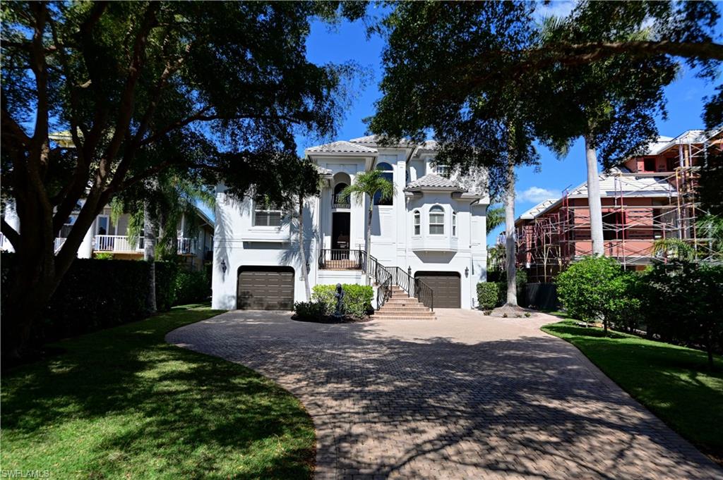 Incredible 4 bedroom, plus den, 4 bath home located in the gated community of Bayfront Gardens within Barefoot Beach.  Features two story living room w/fireplace & outdoor deck overlooking the pool/bay. The kitchen offers breakfast bar, granite counters, custom cabinetry & high quality appliances.  Main floor also features formal dining, office/den & 2 guest suites. 3rd floor includes the grand master suite w/large master bath, marble floors & counters, separate his/her vanities & closets.  Adjacent to the kitchen is a family room & guest suite. Backyard features pool, spa and is totally fenced. Property also includes boat dock with lift & offers quick easy access to the Gulf.  Walk right across the street to the beach via dedicated beach access.