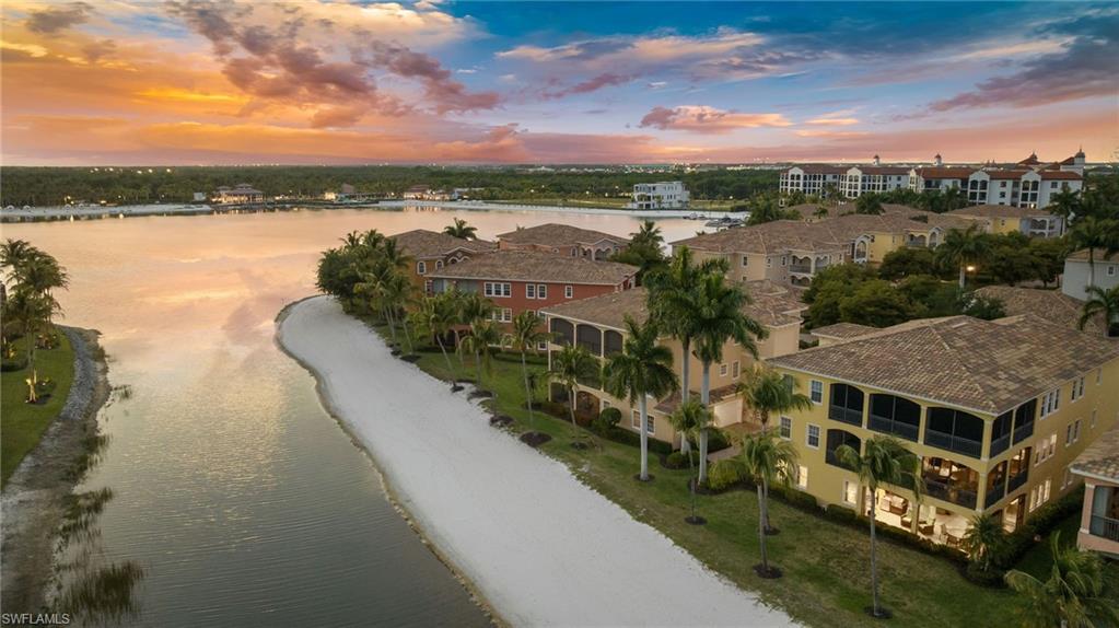 Experience resort-style living in this recently renovated custom coach home perfectly positioned on a beautiful white sand beach overlooking 700 acres of freshwater lake, ideal for boating, water skiing, and fishing. The home has been thoughtfully updated and features a newer HVAC system for comfort and efficiency. Step outside to the spacious lanai that features outdoor kitchen with gas grill, perfect for entertaining while enjoying the breathtaking waterfront setting. The spacious garage with epoxy flooring provides a clean, durable finish and plenty of storage. Located within a prestigious gated community known for its world-class amenities and private beach lifestyle, this stunning coach home offers the perfect blend of luxury, comfort and waterfront recreation.  Miromar features 700 acres of fresh-water lakes, with boating, fishing, swimming, water skiing, 3 miles of sand beaches, Caribbean style beach grill, club house, full-service country club for evening dinning, pool, full-service spa, fitness center, golf, tennis, pickleball, volleyball, basketball, bocce, two marinas, boat rentals and many other luxurious amenities