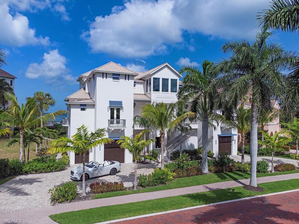 Completed in 2020 don’t miss this expansive “FULLY RE-ENGINEERED” coastal home on Barefoot Beach. This 5600+SF home offered fully furnished features 5 bedrooms + 2 dens. Straight-on Gulf views are provided by this homes center position on one of Barefoots’ Gulf-Front gardens of estate homes.  Spread over 1.5 lots, home has wide West and East Gulf and Bay water views from multiple rooms through walls of floor to ceiling glass.  Home features high end furnishings with coastal flair and wide plank oak floors.  A sprawling main living area features Great room with fireplace, two dining areas, double island kitchen with mitered quartzite tops and Wolf & Subzero appliances.Owners suite has sitting area with fireplace, spa bath with floating tub and connects with two offices, all with sliders to private deck and Gulf views.Four guest rooms are spread over the 2nd and 3rd levels providing privacy for all. This newly rebuilt home includes new impact glass doors/windows, generator, metal roof and smart home technology. First level of home features elegant entry foyer and enormous non conforming bonus room plus garage with multiple vehicle parking. Contact Barefoot Beach Club for membership.