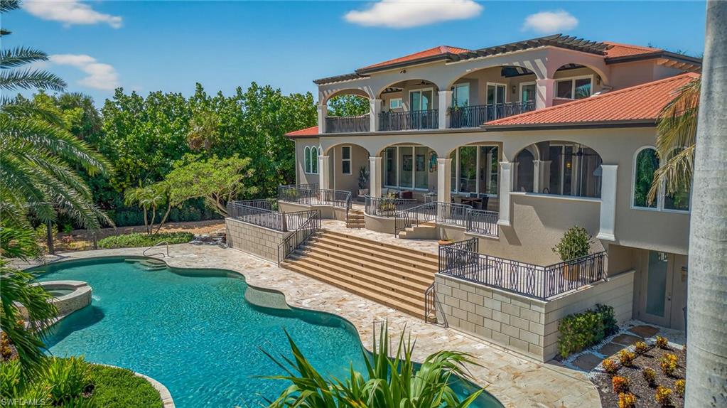 A truly extraordinary tropical oasis, this stunning estate is set just steps from Sanibel’s pristine beaches on a private cul-de-sac surrounded by lush, manicured landscaping. The approximately 1-acre setting feels like a secluded resort, anchored by Sanibel’s largest private residential pool—an 82-ft free form masterpiece framed by an elevated waterfall spa, travertine pavers, custom pergola, tropical grounds with walking paths lined by swaying coconut palms. Whether you’re swimming laps at sunrise or unwinding beneath the stars, every inch of the outdoor space is designed to celebrate the island lifestyle. In perfect harmony with this breathtaking setting, the 5,000 +/- SF home is a modern European-inspired fortress—crafted from solid concrete block, topped with durable Permatile roofing, and built to endure. Impact-rated glass doors and windows invite natural light while offering storm protection. A whole-house Kohler generator, elevated HVAC, Halo water purification system, and private elevator ensure comfort, safety, and peace of mind year-round. Inside, the design is both refined and inviting. A floating white oak staircase under a Murano glass chandelier makes a bold statement, while an open-concept layout flows effortlessly from the living room’s gas fireplace, that anchors the space with warmth and style, to the chef’s kitchen which is a showstopper, outfitted with Wolf & Sub-Zero appliances, walk-in pantry, custom cabinetry, wine fridge, and a beverage center—perfect for entertaining. The 1,200 SF upstairs primary suite offers a tranquil retreat with a private lanai, dual walk-in closets, and a marble-accented spa bath. The main level features 3 ensuite bedrooms including a private in-law suite with a morning kitchen. Touches such as a private office with custom shelving, Sonos system, dual laundry rooms, tankless water heaters, and pet wash stations make this resort style home truly one-of-a-kind.