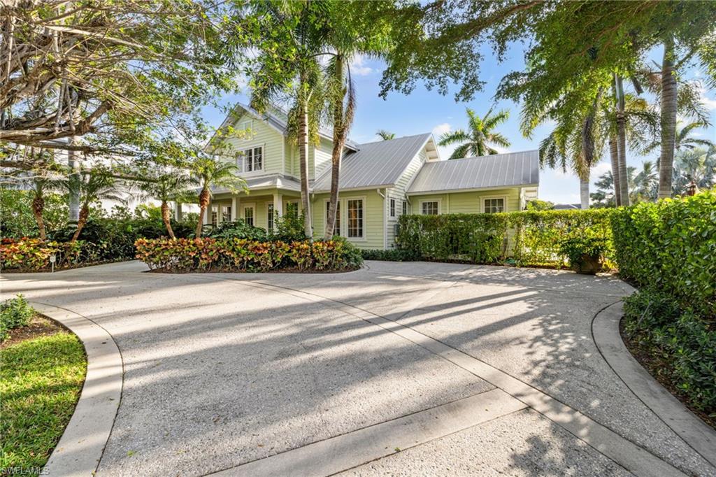 This stylishly updated, fully furnished lakefront beach cottage in Olde Naples offers a bright and open first floor with new terrazzo marble floors, large windows, and contemporary furnishings. The primary bedroom on the first floor features new hardwood floors, a Samsung Art Screen TV, an Avocado organic mattress, and views of the garden, pool, and lake. The spa-like primary bathroom includes a soaking tub, double vanity with marble countertops, new bathroom hardware, elegant lighting, mirrors, and a newly tiled shower with dual high-pressure shower heads. The fully stocked kitchen is equipped with new marble countertops and backsplash, a new dishwasher, ample storage, and a farmhouse sink with a new Insinkerator. The dining area seats six, and the large first-floor laundry room has a new washer and dryer. A powder half bath on the first floor features a new vanity with a marble top. Upstairs, the two bedrooms have vaulted ceilings and can accommodate five people. The east-facing room has a queen bed, while the larger room, facing the backyard, has a king bed and a twin daybed. Both rooms have Samsung Art Screen TVs and generous closet storage. The backyard boasts a heated pool with ambient lighting, a screened-in lanai, a new BBQ gas grill, and a firepit. With views of the lake, the home is just steps away from the beach, the new Four Seasons complex, and a golf course. This property has excellent rental income potential year-round.