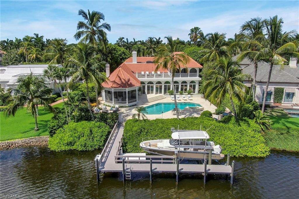 Enjoy panoramic views of Treasure Cove from this renovated four-bedroom plus den home. Featuring over 7,800 total square feet, this Kasimir Korybut design and AVA built property features a timeless appeal with an open floor plan connecting the indoor and outdoor living spaces. With light-filled interiors, attention to detail is highlighted throughout featuring stone flooring, floor to ceiling doors, and exquisite finishes. The main level highlights include a welcoming entryway, gourmet eat-in kitchen with top of the line appliances, formal dining room with water feature views, living room with gas fireplace, private study with folding glass doors adjacent to a comfortable gathering room, and two guest ensuites. The second level includes a stunning and spacious master ensuite with access to a covered balcony, open sundeck overlooking expansive water vistas, and the third bedroom with dual walk-in closets. This spectacular waterfront property, complete with pool, new grill cooking area, covered lanai, boat dock with 16,000 lb lift, create the most gracious setting for a classic and elegant Port Royal retreat.