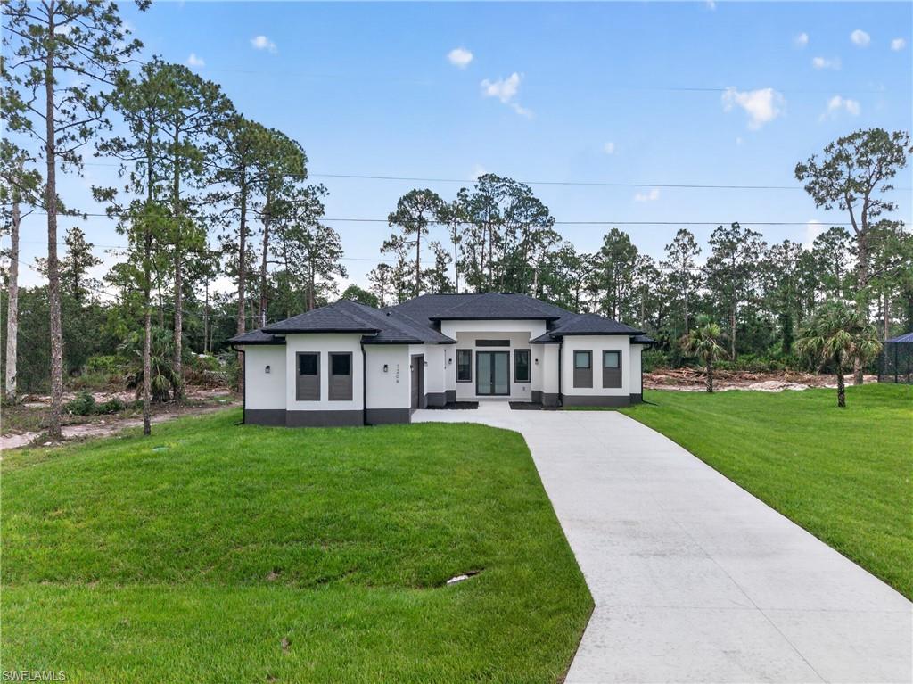 Brand new construction pool home situated on a spacious oversized lot in a quiet area of Lehigh Acres. This 4 bedroom, 3 bath residence features a modern open concept layout with high tray and volume ceilings, wood-look tile flooring throughout, and abundant natural light. The kitchen is equipped with quartz countertops, a large island, white shaker cabinets, and stainless steel appliances, perfect for both everyday living and entertaining. The primary suite offers dual vanities and a beautifully designed walk-in shower with floor to ceiling tile. Enjoy Florida living at its best with a screened in lanai and private pool, ideal for relaxing or hosting. Conveniently located with easy access to major roadways, shopping, and dining while still offering privacy and space.