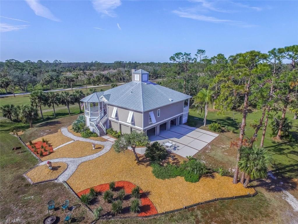 THE HURRICANE PROOF HOME! Natural light streams through the cupola and French doors of this architect designed and custom built Florida style home. The open floor plan, built by Richardson Homes, includes commercial upgrades, breathtaking views from large porches, a dream kitchen, and an Iso-Kern fireplace for warmth or wood-burning for beauty. The master suite opens to the screened back porch and spa, and provide a “tree house” view of sunrises. The ground floor includes a guest suite with kitchenette, full bath, safe room/hobby room, and storage closets plus parking for 3 vehicles. This 4 bedroom, 3 bath home is constructed of polysteel with solid concrete walls and includes commercial grade hollow core cement slab sub-floor. There is a 20 kw generator with automatic transfer switch, Bahama style hurricane shutters, and an alarm/video security system. A 3,000 square foot concrete slab is ready for you to erect an outbuilding to your specs. Property is fenced with agricultural exemption currently in place. The deed includes a 30 foot easement to the Caloosahatchee River for canoe/kayak launching or boat landing. OFFERING PLENTY OF ROOM FOR KIDS, PETS, HORSES, HOBBIES, ATVS, ETC.!
