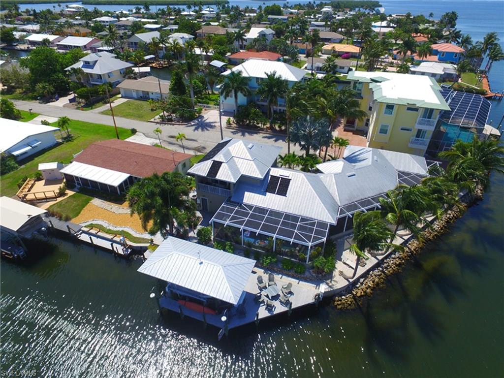 If you are looking for island living, this Matlacha home is a must see. Undoubtedly a home with the greatest views of Matlacha Pass and Matlacha Bridge.  You will never tire of this view and the "action on the water" which includes dolphins, ospreys, pelicans, manatees, kayaks, and boats of all descriptions. This is a well maintained one owner custom built home.  New seawall, dock and 10,000# boat lift with metal roof constructed when house was built. Recently replaced AC units (one for master bedroom and one for lower level), refrigerator, washer/dryer, Gem lift controls with remote for boat lift, circuit boards and pump for salt water pool.
Within walking distance to "downtown" Matlacha, and some of the greatest boating, kayaking, crabbing and fishing in Florida.  Deep water canals and no bridges to Gulf will handle just about any size boat.
Island living at is finest.