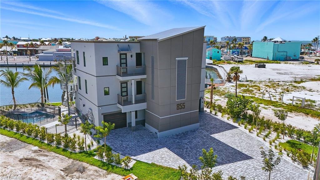 One or more photo(s) has been virtually staged, AI generated or rendered.  PREMIER NORTH-END LUXURY OPPORTUNITY WITH STUNNING LAGOON VIEWS! Experience high-end coastal living in this brand-new luxury residence offering direct Gulf access, a private boat slip, enclosed garage, and beach access just steps away (approximately 400 ft). Built with advanced SIP construction, full hurricane-impact systems, and a newly poured concrete bulkhead, this property combines superior quality with long-term durability. This beautifully designed 2-bedroom, 2-bath condo features a bright, open-concept layout with designer cabinetry, elegant tile flooring, modern lighting, and timeless upscale finishes throughout. Spacious bedrooms provide comfort and privacy, while the main living area showcases breathtaking lagoon views and the iconic Matanzas Pass Bridge — creating a stunning backdrop for everyday living and entertaining. The private boat slip is just steps from your door for quick Gulf access, and the enclosed epoxy-finished garage offers secure parking and valuable storage — a rare luxury on the north end. Residents enjoy a sparkling pool, lush tropical landscaping, and a prime walkable location near Times Square, Margaritaville, Bowditch Point Park, dining, shopping, and convenient on/off-island access. A rare combination of luxury, quality construction, exceptional views, and premier north-end location.
