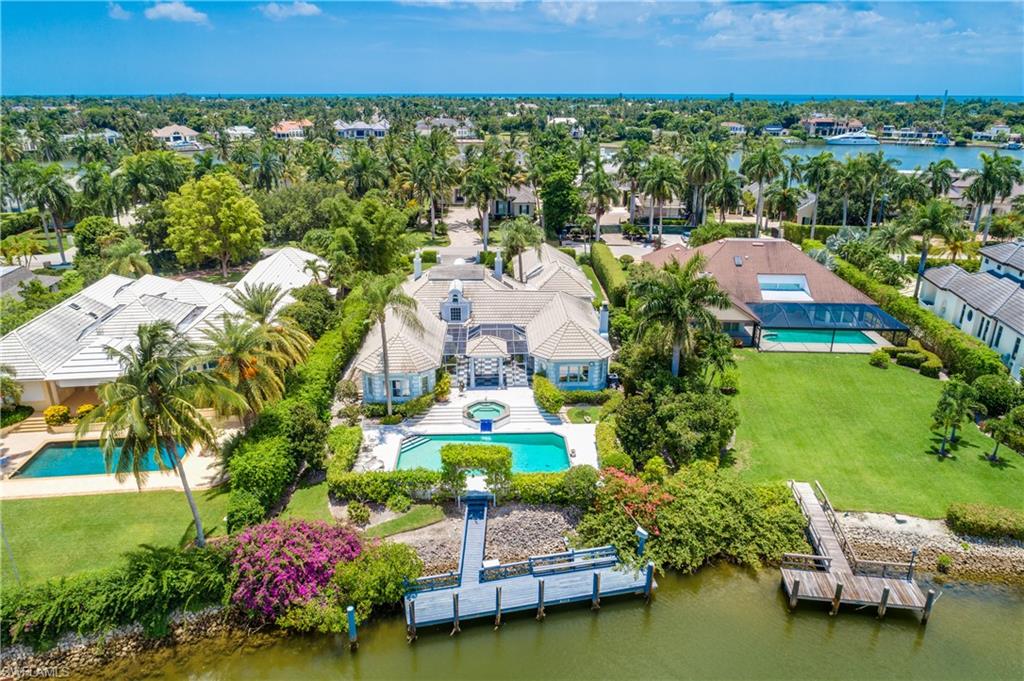 Spectacular wide water views, a large lot and direct Gulf access from a 45-foot deep-draft dock provide the essentials one needs for a luxurious boating lifestyle in Port Royal. European elegance aptly describes the style this estate home emanates with its 9-foot tray ceilings and extensive moldings. A dramatic 2-story entry gallery with marble floors leads to the living room with wet bar, and glass doors open to a mansard-screened outdoor pavilion with a columned sitting area that overlooks the pool, spa and magnificent panoramic waterfront view. The residence of just over 4,800 square feet features a large living room and sophisticated wood-paneled library, equipped with a keystone fireplace. A spacious 3-car garage and whole house generator are additional notable features this home offers. Owners of this waterfront wonderland will also enjoy eligibility for membership to the Port Royal Club. Property sold “as is”.