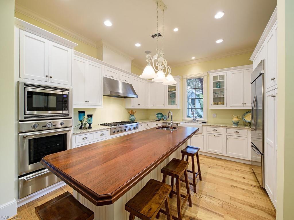 “Beachy Keen” is an IDEAL oasis perched above Gordon Drive in the heart of Olde Naples literally steps to shopping & dining on Third Street S! 2 short blocks to beach! Shows absolutely BEAUTIFULLY in person! Circular brick drive & steps welcome you into a sunny, 2 story entry with unique architecture, tall ceilings, warm wood floors, impact windows & french doors! Foresite-built, 1-owner home maintained well & used sparingly: lives like a much newer home! Open, flowing floorplan makes entertaining easy. Custom kitchen, family room flooded with  light, & separate dining room. Private VIP guest suite accessed right off the kitchen! Downstairs den/study with full bath close by too. Opposite, is the generous master and master bath fit for a couple: 2 vanities, claw foot tub, rainforest shower, dressing table, 2 WCs, and 2 BIG closets. Upstairs? Cozy den for guests, plus 2 large guest suites, each w. own bath. Balcony accessible from both for sunning & reading a great book: offers a peek at the shops on 14th! Outside? Enjoy poolside picnics! Gas grill, fireplace, & wet bar area spill onto a bi-level natural stone patio w.heated pool & spa. Even a fully fenced grassy area ideal for pets!