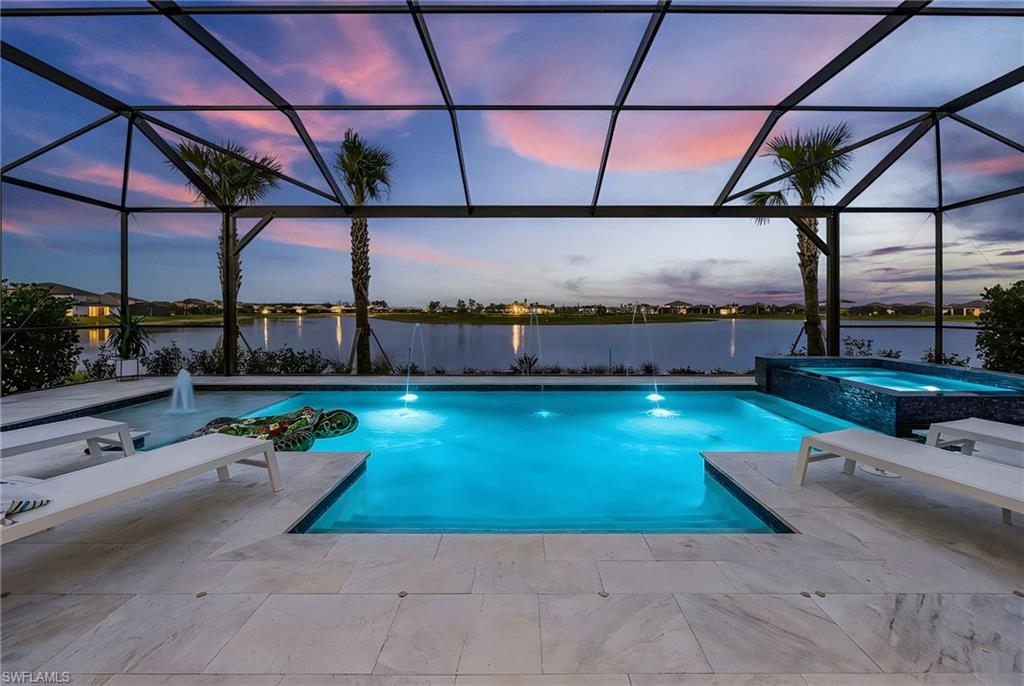 Extraordinary in every detail, this fully upgraded Renown model by Pulte showcases breathtaking, one-of-a-kind long lake views that are rarely available within the community. Perfectly positioned on a premium 95-foot lakefront homesite, this exceptional residence offers an unparalleled blend of luxury, privacy, & resort-style living. Featuring 2,850 square feet of thoughtfully designed living space, the home includes 3 bedrooms plus a Large Den (easily utilized as a 4th bedroom) & 5 bathrooms including a Pool Bath. Every detail has been carefully curated, highest Level kitchen upgrades, engineered hardwood flooring, coffered ceilings, crown molding, wood beams, custom accent walls, designer lighting & faucets, custom drapery, & built-in closet organizers. Additional upgrades include a whole-house filtration system, epoxy garage flooring, EV charger & a 4ft garage extension.
The chef’s kitchen is the centerpiece of the home, showcasing Carrara quartz countertops, marble backsplash, double-stacked glass upper cabinetry, and premium built-in stainless steel appliances, including a 48-inch fridge, gas cooktop, microwave/oven combo & wine cooler, an oversized island & spacious walk-in pantry. The expansive great room is enhanced by zero-corner sliding glass doors, creating seamless indoor-outdoor living, while a custom entertainment wall with fireplace, soundbar, and subwoofer provides the perfect setting for entertaining. The luxurious primary suite offers serene lake views & an oversized layout featuring dual walk-in closets, linen closet & a spa-inspired bathroom with a soaker tub & frameless glass shower. Notably, this home features the largest laundry room and primary closet in all of Verdana Village. Outdoor living is equally impressive, highlighted by a custom heated saltwater pool and spillover spa with black glass accents, sun shelf, and multiple water features. The fully extended marble pool deck & panoramic screened lanai are surrounded by mature six-foot Clusia hedging. The oversized covered lanai is pre-plumbed for an outdoor kitchen & includes a convenient pool bath, making it ideal for year-round entertaining. Within Verdana Village’s resort-style amenities, residents enjoy access to a fitness center, social club, resort-style pool, lap pool, spa, indoor and outdoor pickleball courts, tennis courts, indoor basketball, dog park, on-site dining, and an active community calendar featuring events, food trucks, and live entertainment. The Shops at Verdana Village continue to expand, including a new 10,000-sqft Lee Health medical facility coming soon, alongside Publix, UPS, Duncan Donuts, Dining, award winning Hair Salon, Nail Salon, Physio, Fifth Third & other everyday conveniences. Located just 20 minutes from Southwest Florida International Airport, this home represents a rare opportunity to own one of Verdana Village’s most extensively upgraded & desirable residences. **Seller will pay $10,000 towards closing cost**