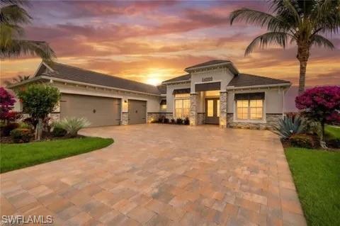 This one is a true showstopper and a must-see! Experience refined lakefront living in this exceptional Bougainvillea floor plan residence located within the highly sought-after resort-style community of WildBlue. Offering 4 bedrooms, 3 full baths, a private study, and an open-concept design, this move-in-ready, fully turnkey furnished masterpiece seamlessly blends luxury, comfort, and the ultimate Southwest Florida lifestyle.

Perfectly positioned on one of WildBlue's pristine lakes, this stunning waterfront property offers the rare opportunity to boat directly from your backyard private dock and explore miles of scenic boating waters. The oversized double dock is equipped with power, water, and integrated lighting, plus two floating jet ski docks, making it ideal for boating, paddleboarding, kayaking, fishing, or simply enjoying life on the water.

With over $200,000 in premium upgrades, every detail of this home has been thoughtfully designed. The expansive outdoor living space features a sparkling pool and spa, outdoor kitchen, spacious covered lanai, breathtaking sunrise views, and a propane gas fireplace surrounded by premium Polywood furnishings. The lanai showcases elegant tongue-and-groove ceilings and a custom built-in outdoor entertainment center with fireplace, creating the perfect setting for year-round entertaining and relaxation. Custom landscaping and landscape lighting enhance the home's beauty and curb appeal.

Inside, the home is loaded with luxury finishes including white cabinetry, premium appliances, a large center island, Bahama shutters, stone exterior accents, custom paint, designer lighting, custom ceiling fans, upgraded mirrors, custom shower doors, and countless designer touches throughout. The spacious great room flows seamlessly into the gourmet kitchen and outdoor living area while featuring a stunning custom shiplap indoor entertainment wall with built-in fireplace.

Being offered fully turnkey furnished, this residence allows the next owner to immediately enjoy the coveted WildBlue lifestyle. The private study provides flexibility for a home office or media room. The owner's suite offers spectacular lake views, a spa-inspired bath, and generous closet space, while guest bedrooms provide comfort and privacy for family and visitors.

Additional upgrades include electric storm shutters, a full-house Generac generator, air-conditioned 3-car garage, custom epoxy garage flooring, and numerous high-end enhancements throughout. WildBlue offers world-class amenities including a clubhouse, restaurant, resort-style pool, fitness center, tennis, pickleball, lakeside beach, and miles of navigable boating waters. Conveniently located near shopping, dining, Gulf Coast Town Center, FGCU, and Southwest Florida International Airport, this extraordinary property delivers an unmatched combination of luxury, convenience, and waterfront living.