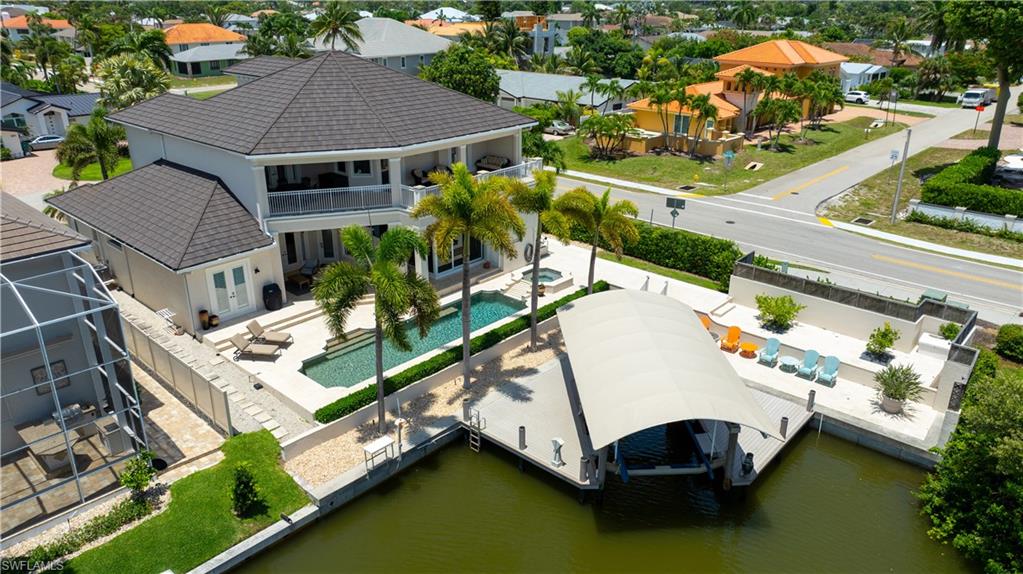 Experience the pinnacle of coastal luxury in the heart of Vanderbilt Beach. Perfectly positioned on a serene canal with Gulf access, this exceptional waterfront residence offers an unparalleled blend of elegance, comfort, and boating convenience. A private covered dock with a 20,000-pound boat lift provides effortless access to the Gulf, while the resort-style pool and spa create a stunning backdrop for both relaxation and entertaining. Designed to capture natural light and breathtaking water views, the home showcases soaring ceilings, exquisite marble flooring, and an open, flowing floor plan. The chef’s kitchen is appointed with premium appliances, a gas cooktop, abundant workspace, and seamless connectivity to both casual and formal living and dining areas, ideal for intimate gatherings or grand-scale entertaining. The expansive first-floor primary suite serves as a private retreat, offering generous proportions and a luxurious ambiance. Upstairs, guests and family will enjoy three spacious bedrooms, three bathrooms, a dedicated office, and a massive flex room perfectly suited for a media room, fitness space, or additional gathering area. An expansive terrace overlooks the sparkling pool, spa, and tranquil canal, providing the perfect setting for morning coffee or evening sunsets. Outdoor living is equally impressive, with abundant covered and open-air spaces designed to embrace the coveted Naples waterfront lifestyle. Whether hosting unforgettable gatherings, enjoying a day on the water, or simply unwinding by the pool, this remarkable residence delivers the very best of coastal living. Located just moments from the sugar-sand beaches of the Gulf, this premier Vanderbilt Beach address offers close proximity to world-class dining, upscale shopping, luxury hotels, and the vibrant attractions of Naples. This is a rare opportunity to own an extraordinary waterfront estate in one of Southwest Florida’s most sought-after coastal communities.