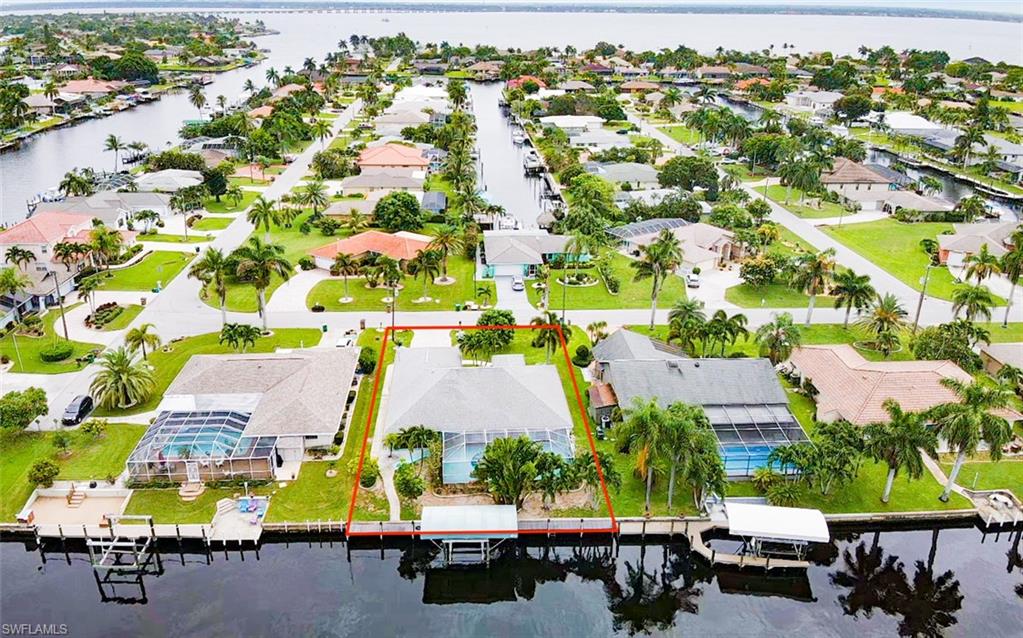 Calling all boaters!!! Premier Direct sailboat access to Gulf waters w/no bridges, one turn to the Caloosahatchee River. Pool home built in 2000, with over 1,900sq ft features 3 bedrooms 2 baths, western exposure, open concept w/high ceilings, new ceramic plank tile throughout the home, a wall of glass pocket sliding doors allowing natural light to the large family-dining room areas & kitchen. Black granite counters, white cabinets, plus breakfast bar opening to breakfast nook and great area, perfect for entertaining! Oversized principal bedroom w/coffer ceiling, direct pool access, large walk-in closet & bathroom w/soaking tub. Secondary bedroom w/private entrance to bathroom & pool, walk-in closet, and additional bedroom w/double Murphy beds & built-in office!  Enjoy beautiful sunsets from your own large tile lanai and pool area. Great garden with new sprinkler system, water heater, A/C unit both located in the garage, pool filter motor, kitchen ceiling recessed lighting & new ceiling fans in living area and lanai. The dock is the width of the property and is made of composite boards, concrete sea wall, and 10,000 lbs boat lift. Perfect location close to shopping & entertainment!