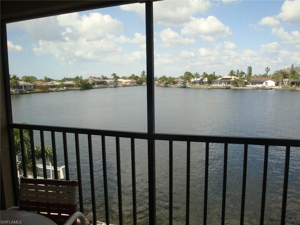 Light and bright, this one-owner Gulf Access Condo has AMAZING LAKE views!  This 2 bedroom, 2 bath condo is situated in a wonderful location, walking distance to the Publix located on Cape Coral Parkway, yet on a quiet side street.  The minute you enter this 2nd floor unit you are just drawn to the wide open lake view, watch the fish jump and the manatees come close.  The unit comes Turnkey and is in move in condition with tile in the kitchen and entryway and new carpeting though-out.  Dock space is available for your boat and assigned upon request.
