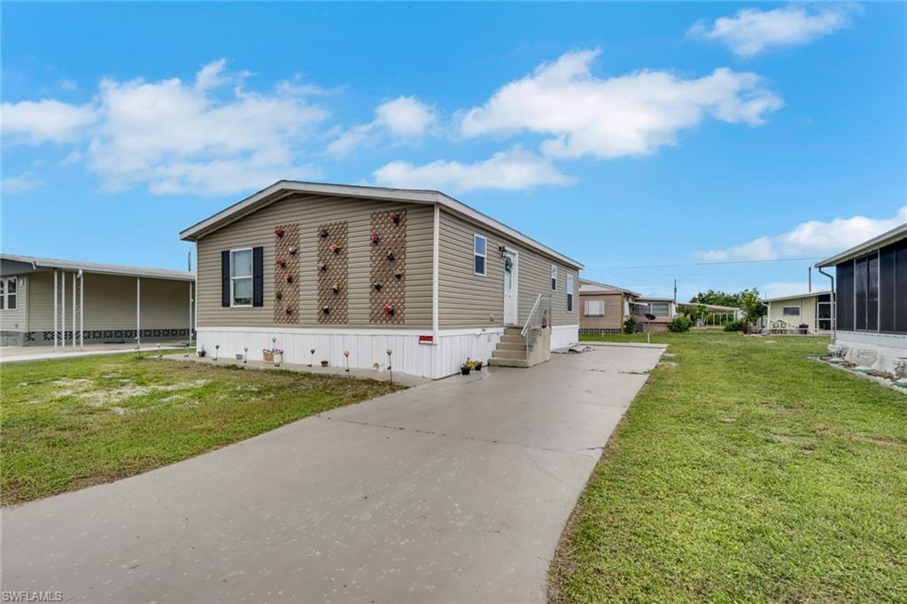 Welcome to Carriage Village, one of North Fort Myers' most desirable resident-owned 55+ communities! Built in 2022, this beautifully maintained 3-bedroom, 2-bath modular home offers the perfect combination of modern design, low-maintenance living, and exceptional value. Seller has already paid for a carport and a shed to be built just waiting on the contractor to finish installing. Permit has already been pulled in engineering is completed.

Step inside to discover a bright, open-concept floor plan featuring spacious living and dining areas, abundant natural light, and a stunning custom wood coffered accent wall that adds warmth and character to the main living space. The thoughtfully designed kitchen is a chef's delight, offering generous cabinetry, abundant storage, and plenty of workspace for everyday living and entertaining.

Constructed with quality and peace of mind in mind, this home is anchored to the ground and engineered to withstand hurricane-force winds up to 135 MPH. It has experienced no hurricane damage, providing added confidence for future homeowners.

Outside, enjoy the newly repaved extra-wide driveway with parking for two vehicles. A brand-new attached carport and storage shed are scheduled for completion by August 2026, adding even more convenience and functionality. The HOA also permits homeowners to install fencing, allowing you to personalize your outdoor space if desired.

Carriage Village is a resident-owned community, meaning you own the land—no land lease! Residents enjoy incredibly low HOA fees and an active social calendar filled with clubs, activities, and community events, creating an inviting and vibrant lifestyle.

Ideally located near shopping, restaurants, golf courses, medical facilities, entertainment, and convenient access throughout Southwest Florida, this move-in-ready home is perfect as a full-time residence, seasonal escape, or affordable Florida retreat.

Don't miss this opportunity to own a newer home in one of North Fort Myers' most sought-after communities. Schedule your private showing today and discover everything Carriage Village has to offer!
