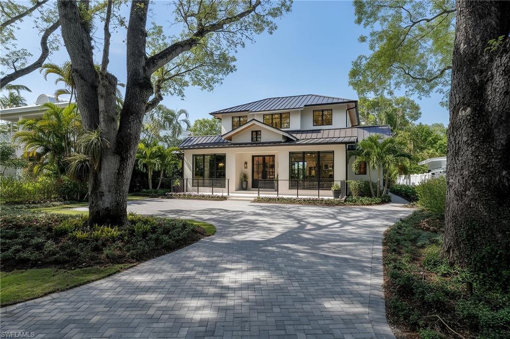 This extraordinary custom-designed home is the epitome of luxurious living in downtown Naples. A true collaboration of the distinguished C&E Builders and the celebrated Ruta Menaghlazi of Theory Design—this one-of-a-kind property effortlessly blends impeccable craftsmanship with modern elegance. Located just moments from the pristine sugar-sand beaches and within walking distance to the world-class shopping, dining, and entertainment of 5th Avenue South, 3rd Street, and the highly anticipated Naples Beach Club, it offers an unparalleled lifestyle. Upon entering, you are greeted by an breathtaking floating staircase that serves as a striking focal point of the home. The open-concept floorplan is bathed in natural light, with soaring ceilings adorned with wood beams that create a beautiful contrast against the sleek ebony accents throughout the home. This is no ordinary new construction—it's a masterpiece that balances warmth and sophistication in a way that feels uniquely refined and inviting. The heart of the home is its exquisite chef’s kitchen, where luxurious marble countertops and backsplashes provide a breathtaking backdrop to an expansive center island—perfect for entertaining and casual dining alike. This culinary haven features top-of-the-line Miele and Sub-Zero appliances, a dream for any gourmet chef, while the tastefully concealed butler’s pantry enhances the kitchen’s functionality, providing ample space for prep and storage. The primary suite is a retreat, curated for relaxation and comfort. The spa-like master bathroom features stunning marble tile, a luxurious soaking tub, and an oversized shower with multiple showerheads for a true resort experience. Step outside to the tranquil pool area, surrounded by lush landscaping. Designed for entertaining, this home boasts an exceptional indoor-outdoor flow. The outdoor space is adorned with a custom-built fireplace, a summer kitchen, and stunning marble accents, creating the perfect environment for alfresco dining or lounging by the pool. Upstairs, an additional living area serves as a versatile loft complete with a full wet bar—ideal for guests or family members to enjoy their own private space separate from the main living area downstairs. The upper level also features the VIP guest suite, equipped with a full kitchenette, making it the perfect in-law or au pair suite for extended stays. With over 5,000 square feet of thoughtfully designed living space, this home represents the pinnacle of indoor-outdoor living in Naples. The blend of European white oak wood flooring, elegant architectural details, and a sophisticated color palette sets the tone for a residence that is both timeless and contemporary. This custom-built masterpiece is more than just a home—it’s a testament to the finest in Naples living, where every detail has been carefully designed for those with discerning taste.