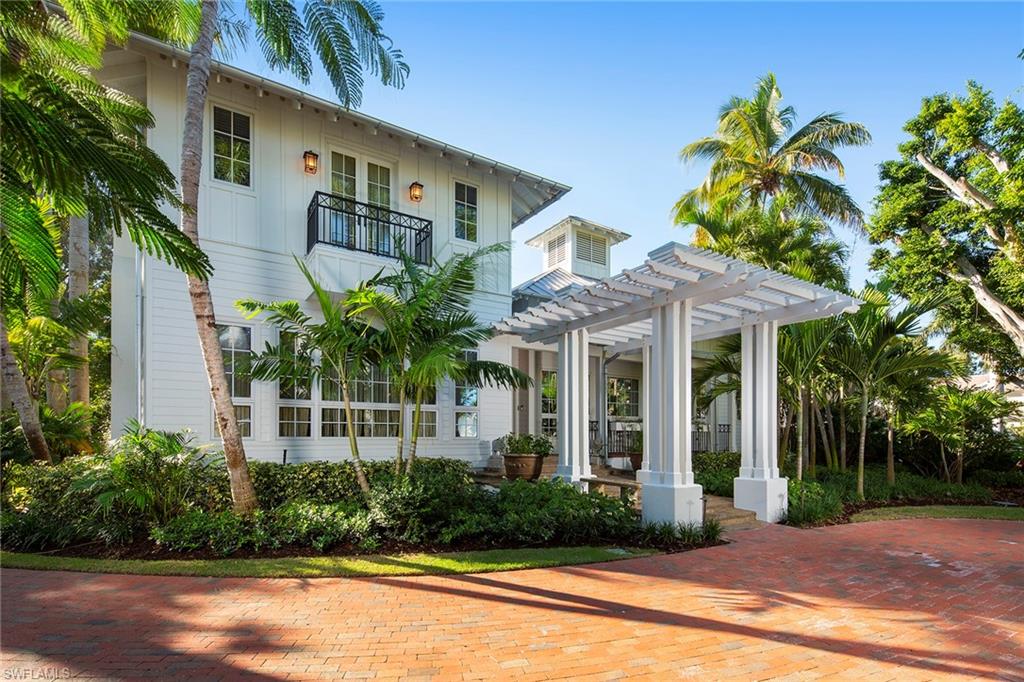 Less than 2 blocks from the beach and perfectly situated just south of Olde Naples, in Aqualane Shores sits this Old Florida gem. Hardiplank siding, a Galvalume roof and ideally nestled within a variety of mature landscaping this estate provides a highly sought-after coastal elegance. A charming trellis greets residents and guests through to the grand hallway framed by custom board and bead walls and French glass doors which lead to the courtyard with pool and spa. Encompassing over 6,000 square feet, this thoughtful design includes a generous kitchen which seamlessly opens to the light and bright family room. A formal dining complete with custom built ins, a gracious master suite inclusive of a separate sitting room with floor to ceiling shelving and 3 separate en-suite guest suites which provide privacy and comfort. This idyllic Naples retreat sits steps away from the white sandy beaches of the Gulf and only a short stroll to the world-class shopping and dining offered on 5th Ave and 3rd St.
