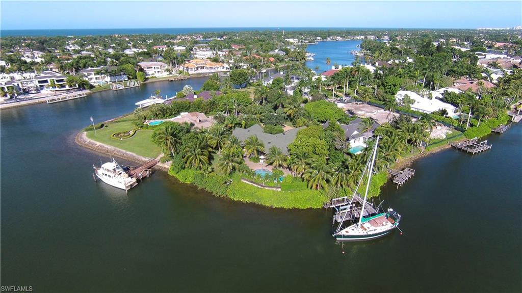 Enjoy the impressive long and open water views of Galleon Cove from this private and tropical setting located at the end of a cul-de-sac. This treasured location offers a south-facing property, which wraps around and boasts 206 feet of water frontage on wake-free protected water. The unobstructed and panoramic views are enjoyed from the home, which features a vaulted-ceiling family room with wood-burning fireplace, enclosed lanai area, open-air pool and spa, and dock with lift.