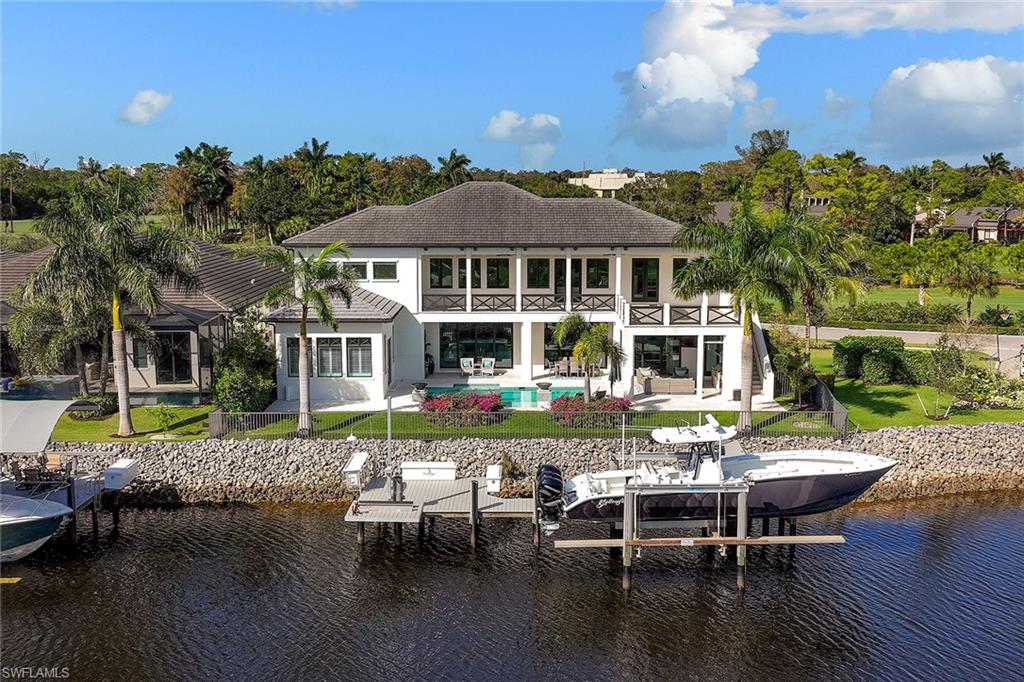Exceptional waterfront property located within the Landings at Bear's Paw - one of just 22 private homes nestled between the Bear's Paw golf course, Greenway Park and the Gordon River. West Indies-inspired architecture, designed by MHK, features a custom mahogany front door with balcony above and 3-car + golf cart garages. Impressive entry opens to southern views of the waterfront outdoor living area with pool, spa and outdoor kitchen. Private dock has a 16,000 lb lift & can accommodate a 42-foot boat, including a separate jet ski lift. Main living area boasts an expansive open living concept plan with Wolf/Sub-Zero chef's kitchen, wet bar, quartz counters & backsplash, double-sided ledge stone fireplace, frameless glass wine room, formal dining, and glass staircase railing. Primary bedroom and office on the first floor, while the second floor features expanded balcony with fire pit, three bedrooms, four bathrooms, second laundry and spacious game/media room with full wet bar. A truly unique opportunity to live in a gated golf course & boating community with Gulf access. Enjoy social membership to Bear’s Paw Country Club, with the opportunity for full golf membership.