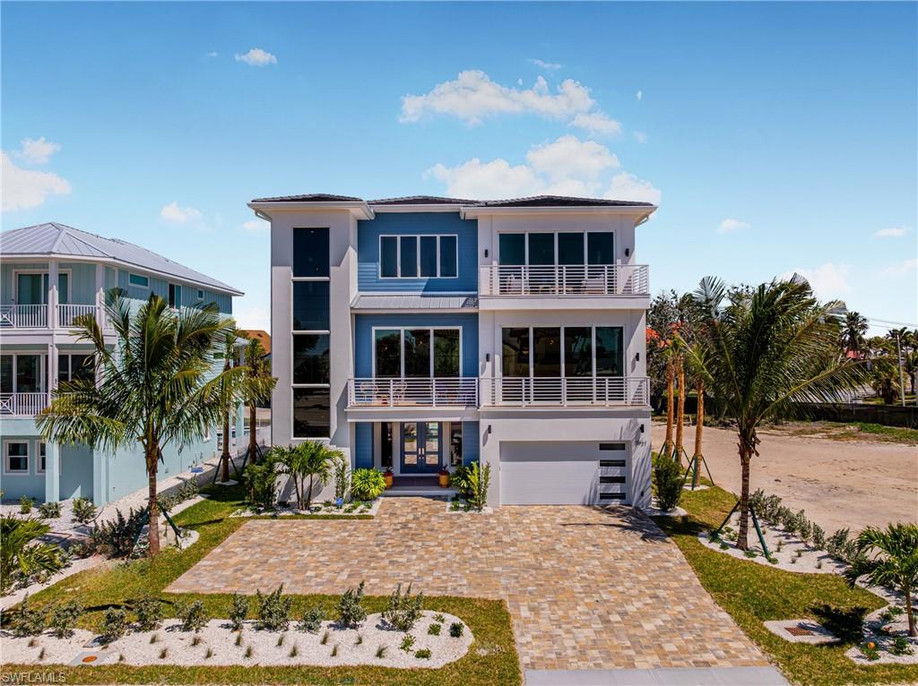 Overlooking the pristine sands of Fort Myers Beach, this BRAND NEW custom-built 3 story home by Imperial Homes offers the perfect blend of contemporary architecture and classic coastal charm. Designed as the ultimate luxury retreat, this 4,392 sq. ft. residence features 4 bedrooms and 4.5 bathrooms, with every detail thoughtfully curated to maximize panoramic Island/Gulf views, comfort, and elegance. Offered FULLY FURNISHED with design by Clive Daniel Home’s Sherie Weidner, the interiors reflect a modern take on “coastal vacation,” incorporating light natural woods, glass, and stone to create a truly unique and sophisticated atmosphere. From the moment you step inside, the open-concept layout captivates with high-end finishes, vaulted ceilings, and seamless indoor-outdoor integration. Floor-to-ceiling windows and multiple balconies frame breathtaking Gulf vistas, while the state-of-the-art chef’s kitchen, complete with top-tier appliances, a spacious island, and custom cabinetry, is ideal for both entertaining and everyday living. The luxurious primary suite serves as a private sanctuary, featuring a spa-like bathroom, walk-in closets, and a serene balcony. A separate game room, a striking rock wall fireplace, and a stylish martini lounge add to the home’s standout design. Outdoor living is elevated with a covered lanai, resort-style pool with spa, and beach access across the street, creating the ultimate setting for relaxation. Smart home technology allows for effortless control of lighting, climate, and security, ensuring modern convenience. Hurricane-resistant construction, impact-resistant windows, reinforced structural elements, and elevated foundations, this home is designed to withstand Florida’s weather. Energy-efficient features, including high-efficiency HVAC systems and smart irrigation, enhance sustainability without compromising luxury. This stunning home is a rare opportunity to own a piece of paradise on Fort Myers Beach in one of the best residential locations on the island!