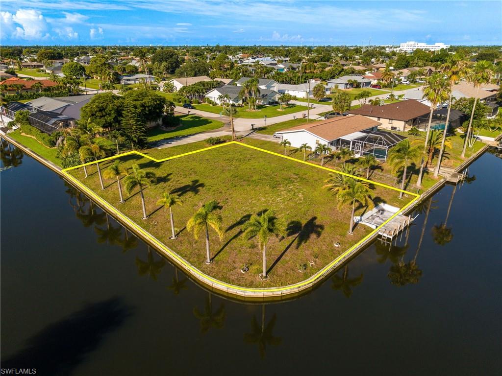 Build your dream waterfront estate on this premier corner lot situated in a highly desirable neighborhood of Southeast Cape Coral. Offering an expansive canvas along the water, this cleared piece of paradise is ready to welcome a custom residential masterpiece.  Lined with mature palm trees that reflect perfectly off the calm canal, this location delivers the quintessential Southwest Florida lifestyle. Surround yourself with beautiful single-family homes in a quiet residential pocket. Seamlessly transition from your backyard to open water adventures. The aerial perspectives showcase the neighborhood's pristine layout, wide clean canals, and close proximity to intersecting water pathways.
Whether you are looking to design a sprawling modern estate with a resort-style pool or a classic Florida oasis, this lot represents a rare opportunity to secure premium gulf access real estate. Bring your builder and start living the ultimate boater's lifestyle today!