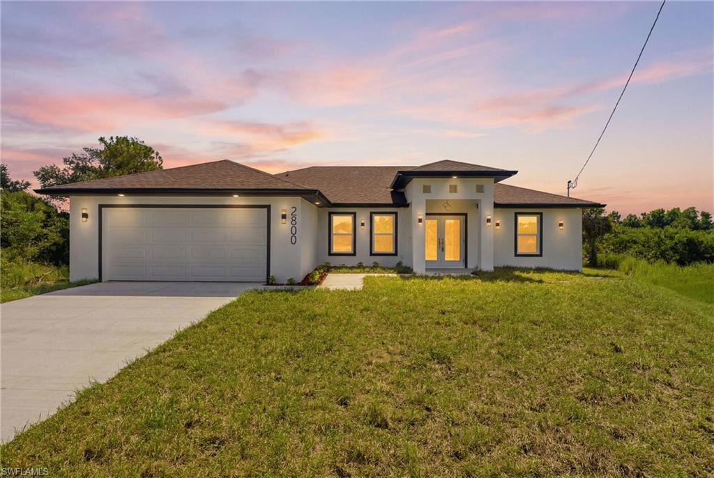 Welcome to this beautifully crafted new construction home located at 2800 Nora Ave N, Lehigh Acres, FL 33971. Offering 2,505 total square feet, this thoughtfully designed 3-bedroom, 2-bathroom residence combines modern elegance with functional living.
Step through the impressive French front doors into a bright, open-concept floor plan featuring tray ceilings in the family room and primary suite, creating an inviting sense of space. Large, picturesque sliding glass doors seamlessly connect the indoor living areas to the expansive screened lanai, with convenient access from the primary bedroom, kitchen, and second bathroom—perfect for enjoying Florida's indoor-outdoor lifestyle. The spacious backyard offers plenty of room to add your dream pool.
The split-bedroom floor plan provides privacy for the primary suite, which serves as a luxurious retreat complete with private patio access, a tray ceiling, an oversized walk-in closet with custom shelving, and a spa-inspired en-suite bath featuring dual vanities and a large walk-in shower.
Designed with both entertaining and everyday living in mind, the kitchen boasts an island with a built-in wine cooler, ample cabinetry, and an open flow into the spacious family room. Ceiling fans throughout the bedrooms and family room add comfort year-round.
Additional features include a dedicated laundry room with a utility sink, a spacious two-car garage, and quality finishes throughout.
Lehigh Acres continues to attract homebuyers seeking exceptional value, newer construction, and larger homesites while remaining within convenient reach of Fort Myers, Southwest Florida International Airport, shopping, dining, healthcare, and Gulf Coast beaches. Continued residential and commercial growth throughout the area has fueled increasing interest from both primary homeowners and investors, making this an outstanding opportunity to own a brand-new home in one of Southwest Florida's fastest-growing communities.