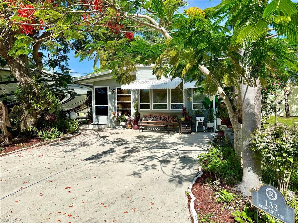 Welcome to 133 Redwood Lane situated in the Holiday Manor (55+) Co-Op of tropical Naples, Florida! This charmingly quaint community offers a boat launch and docks that access the Gulf via canal, a heated pool, hot tub, shuffleboard, billiards, laundry facility, exercise equipment, and a recreation hall (that holds weekly and monthly activities). The community is within walking distance of Walmart, shopping, and restaurants. Plus, Marco Island beaches and Naples beaches are both approximately 5-9 miles away (depending on the specific beach you choose)! This cozy, affordable, and ideally located residence could be just the escape you’ve been searching for. It features 1Br, 1.5Ba, and a bonus room currently used as a hair studio. The main bedroom is located next to the full bathroom with the half bathroom next to the hair studio and laundry room. The home is being sold furnished and additionally provides a daybed in the living room for an extra sleeping option. To manage your storage needs, the laundry area is spacious. On top of all of this, you will love the fruit trees and luscious vegetation that encompasses the home to give you that truly tropical vibe. This beautiful plant-life is very well-maintained. Holiday Manor is a pet-free community.