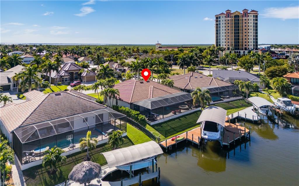 An exceptional sailboat-access waterfront retreat ideally positioned directly across from Cape Harbour. This 4-bedroom, 2-bath residence embodies the ultimate Southwest Florida boating lifestyle, just 230 steps from Fathoms Restaurant & Marina. Designed for effortless luxury and seamless indoor-outdoor living, the home features 2,238 square feet of thoughtfully designed living space, a saltwater pool and spa within a fully screened lanai, and a spacious screened front patio perfect for relaxing and entertaining year-round. Boating enthusiasts will appreciate the private dock with a 16,000-pound boat lift and canopy, offering direct sailboat access to open water with no bridges. Built in 2011 and offered fully turnkey furnished, this meticulously maintained home has never experienced flooding during any hurricane, providing exceptional peace of mind. Whether you're seeking a full-time waterfront residence, a seasonal retreat, or an investment opportunity, this property delivers an unparalleled combination of privacy, and premier boating access in one of Cape Coral's most desirable waterfront locations.