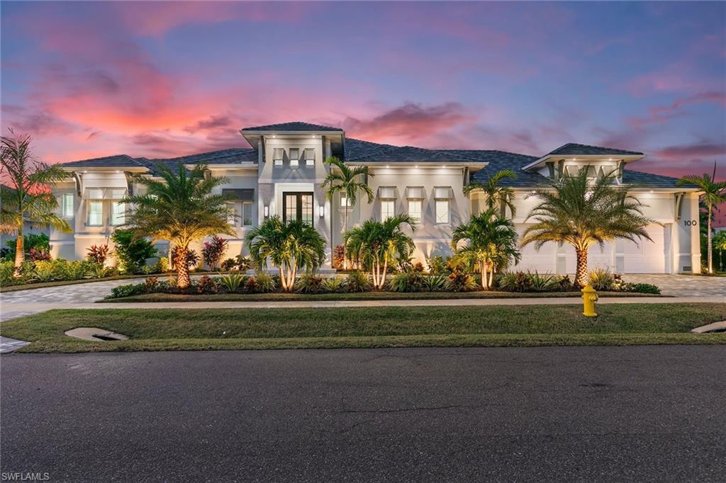 Why wait years to build when this exquisite 2023-built residence awaits? Offering 3,539 square feet of air-conditioned living space, this home features three bedrooms, each with walk-in closets and private baths, plus an additional one and a half baths. Refined details include engineered wood flooring with a natural, aged finish and Brilliant Smart Home automation for seamless control of lighting, music, and communication. The chef’s kitchen features GE Monogram appliances, including a gas stove, wine and beverage center, Sub-Zero refrigerator, and a walk-in pantry for convenient storage. Motorized blinds add a modern touch to all bedrooms and the private office, which enjoys serene water views. Perfect for entertaining, the home offers in-ceiling Sonos speakers, ceiling fans, and an expansive outdoor area. The 1,709-square-foot pool deck includes a sun shelf, fountains, hot tub, gas fire pit, outdoor shower, and a lanai with motorized screens for comfort and privacy. The fully equipped outdoor kitchen includes a grill, sink, refrigerator, and ice machine. Additional highlights include a 3-car garage with epoxy floors, a circular driveway, a 24 kW whole-house generator, two AC units, and a 500-gallon propane tank. The fenced side yard is ideal for pets, and the dock pilings are ready for a customized dock, with electric and water connections already installed. Positioned for breathtaking west-facing sunsets, this home also offers a front-row seat to the annual Christmas parade and peace of mind with no flooding from recent hurricanes.