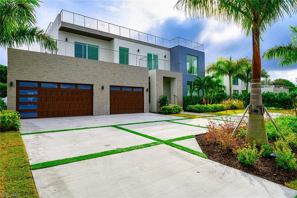 This spectacular 5372 sq ft home with roof top deck is now ready. This home features 4 bedrooms 6 bathrooms and is perfect for entertaining.  The 1st fl has an open living design with beautiful kitchen and living room areas and a guest bedroom.  The kitchen has custom cabinets, natural quartzite countertops, gorgeous crushed shell backsplash along with Miele appliances to make this kitchen special.  The home also features custom remote controlled blinds. Two sets of pocket sliders access the covered lanai and outdoor kitchen.  Outside you will find an inground swimming pool and spa with sun deck.  Access the second floor via the pneumatic elevator or custom staircase.  All bedrooms on the second floor are en-suite and have access to a balcony directly from each room.  The master bedroom has an incredible walk in closet and spa like bathroom.  The roof top deck with outdoor kitchen and bath must not be missed.  The view is amazing!  The home also has a three car garage  with storage area.  This home is a must see!