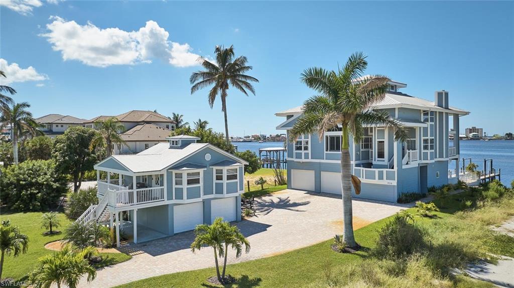 This is the Fort Myers Beach property that truly has it all—bayfront luxury with Gulf views, oversized grounds, income potential, and resort-style amenities. With 7 bedrooms, 5 bathrooms, and an elevator, this exceptional estate is designed for both comfort and convenience, offered fully turnkey. The main residence rises three levels above a private apartment that opens directly to the heated pool and jacuzzi. Multiple balconies and screened decks capture long water views, while the top-level bedroom lookout provides a panoramic perspective of both Estero Bay and the Gulf of America. A wood-burning fireplace adds warmth and character to the spacious living areas. A separate guest house with its own garage sits at the front of the property and is currently leased to a long-term tenant, delivering a proven consistent annual rental income. The main home also offers excellent rental income, making this both a lifestyle retreat and a smart investment. Boaters will appreciate the private dock, complete with a captain’s walk and a 10,000 lb. boat lift—ideal for quick access to open water. The oversized lot enhances the estate feel, providing rare space and privacy on Fort Myers Beach. Perfectly located to avoid the heavy beach traffic yet just minutes from the shoreline, dining, and entertainment, this property offers the best of island living. With unmatched views, exceptional amenities, and turnkey convenience, this is one of the most remarkable opportunities on Fort Myers Beach.