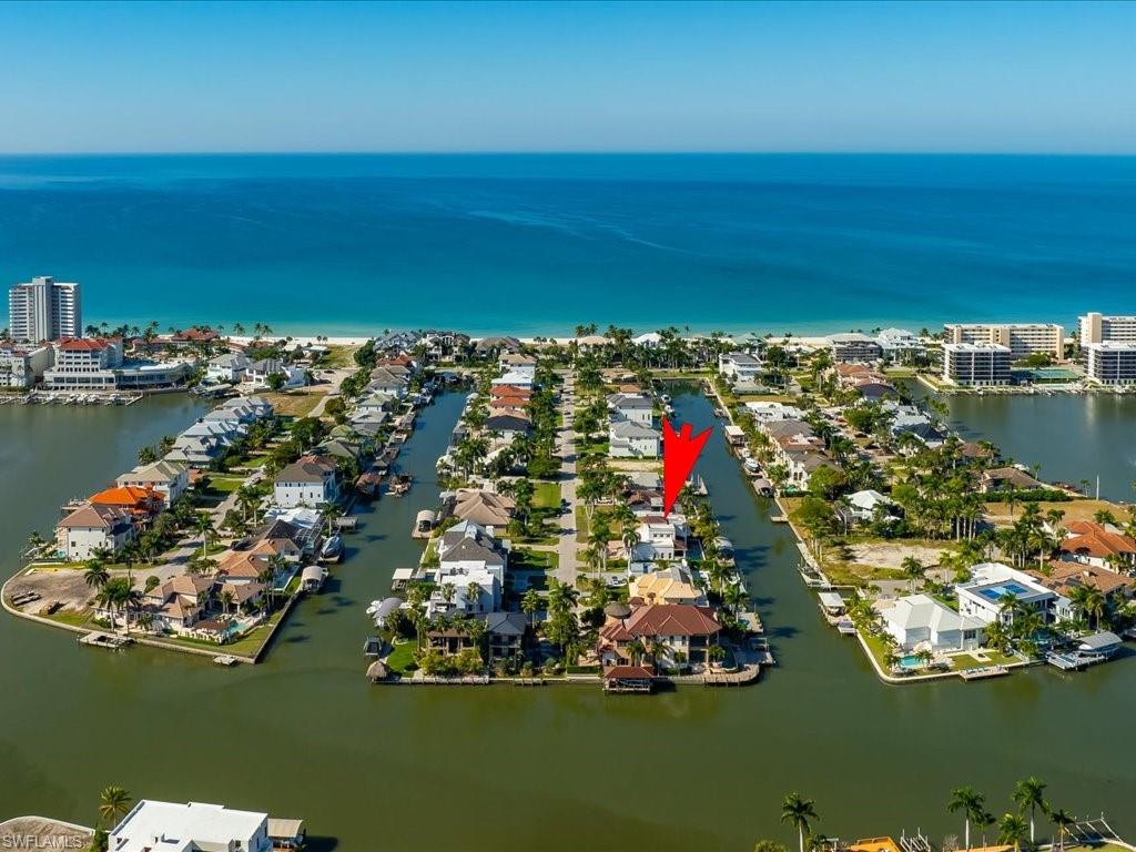A rare gem in Naples, this 5-bedroom, 4 full-Bath / 1 half-bath estate offers the best of both worlds: Direct Gulf Boat Access with a 27,000-pound COVERED BOAT LIFT right out your back door & exclusive Vanderbilt Beach PRIVATE BEACH ACCESS just across Gulf Shore Drive. Nestled in an exclusive enclave of only three peninsula streets that uniquely combine direct beach and boat access, opportunities like this—a boater’s dream and beach lover’s paradise—are truly rare. Spanning 4,050 sq. ft. of living space (5,340 total), the home features two spacious primary suites (one on each floor), an open-concept kitchen, a formal dining area, soaring ceilings, a home office, and a versatile 'bunk room.' Outside, enjoy the ultimate Florida lifestyle with a luxurious pool and spa, along with a Boat Dock and Lift that make getting out on the water effortless. The proximity to upscale dining, shopping, and art galleries puts the Naples lifestyle right at your fingertips.                                            ***INVESTORS: Excellent Rental Income Potential***