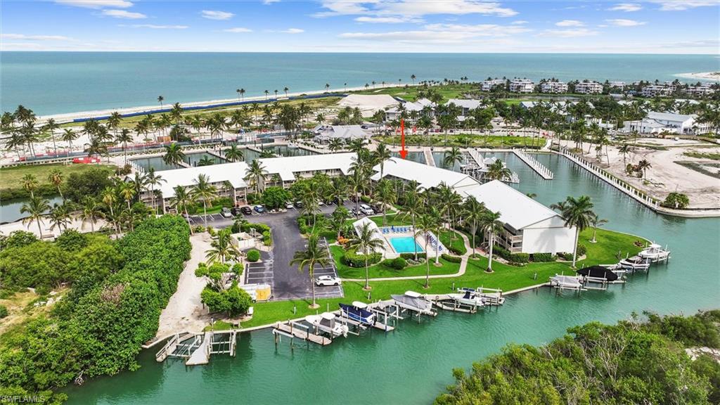 Wake each morning to panoramic yacht harbor views and the gentle rhythm of island life from this updated waterfront retreat in Marina Villas, where Captiva's sugar-sand beaches and the sparkling Gulf of Mexico are just a short stroll away. Ideally positioned on the quiet north end of South Seas Island Resort, this furnished residence overlooks the yacht harbor and navigable channel, offering a front-row seat to passing boats, dolphins, manatees, pelicans, and unforgettable coastal sunsets. The light-filled interior features an open-concept floor plan with tile flooring throughout, a spacious kitchen with warm wood cabinetry and generous storage, plus comfortable living and dining areas that flow seamlessly to the screened lanai. The primary suite offers tranquil water views and an en-suite bath, while the guest bedroom and second full bath provide comfortable accommodations for family and friends. Surrounded by water on three sides, Marina Villas is one of Captiva's most desirable waterfront communities, offering a beautifully maintained setting, a community pool, and association boat docks available by reservation. Just a short stroll from Sunset Beach, the South Seas lagoon-style pool complex, restaurants, and the yacht harbor, this exceptional property is perfectly suited as a private island retreat, seasonal getaway, or investment opportunity where boating, beach days, and the natural beauty of Captiva are always within easy reach.