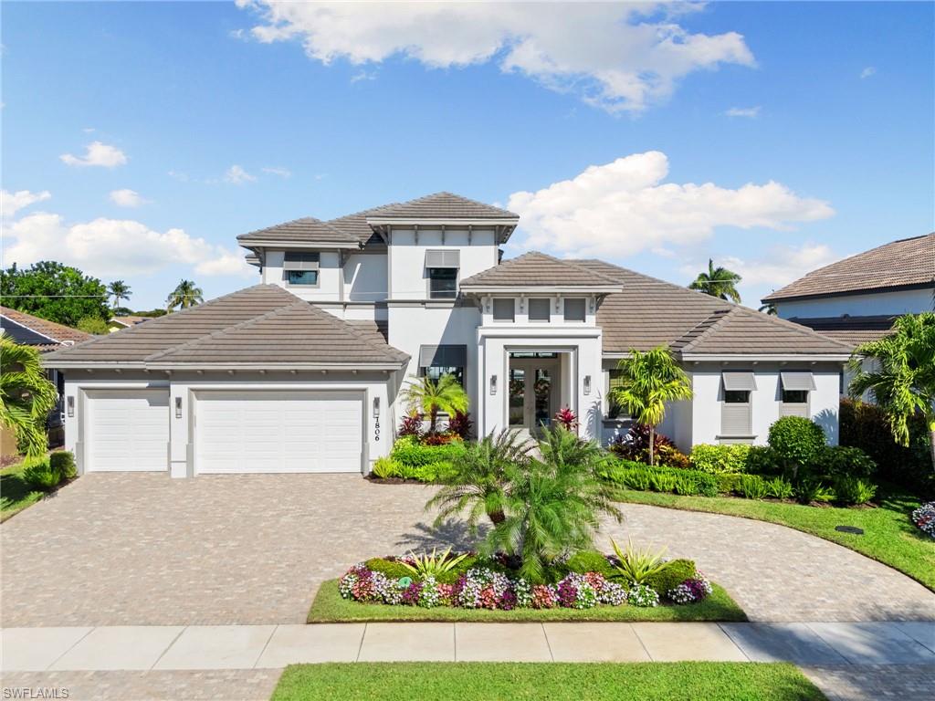 Experience luxury waterfront living at its finest! This stunning move-in ready 5 Bedroom plus office/den, 4 bath residence, built in 2019 is being offered turnkey furnished. Designed for both comfort and elegance, this exceptional home features an impressive 4-car garage, brick paver circular driveway, whole house generator, and quick direct boating access from your private boat dock complete with a 20,000 lb. boat lift and two jet ski lifts. Step inside to a spacious open floor plan highlighted by high-volume ceilings and beautiful tile flooring. The gourmet kitchen showcases high end Jenn Air stainless steel appliances including a gas stove, large center island, and a walk-in pantry that's perfect for everyday living. The first floor primary bedroom suite offers a private retreat with a sitting area, walk-in closet, dual vanities, walk-in shower, and separate soaking tub. The main level also includes a dining area, sitting area, laundry room, office/den, second bedroom, and pool bath. Upstairs, you'll find an entertainment loft, three additional guest bedrooms and two full bathrooms providing ample space for family and guests. Outdoor living is equally spectacular. Enjoy the heated resort-style screened-in pool and spa, or relax under the covered lanai featuring a built-in summer kitchen and dining area. The lanai is further enhanced with remote controlled electric hurricane screens. Additional upgrades include new landscaping, landscape lighting, sprinkler system, dock lighting, smart window shades, an epoxy finished garage floor with built-in storage cabinetry, and a Jandy Aqualink pool system for convenient remote control use. Great location for shopping, restaurants, and riding bikes to the beach. This home delivers it all, offering the ultimate island lifestyle on Marco Island.