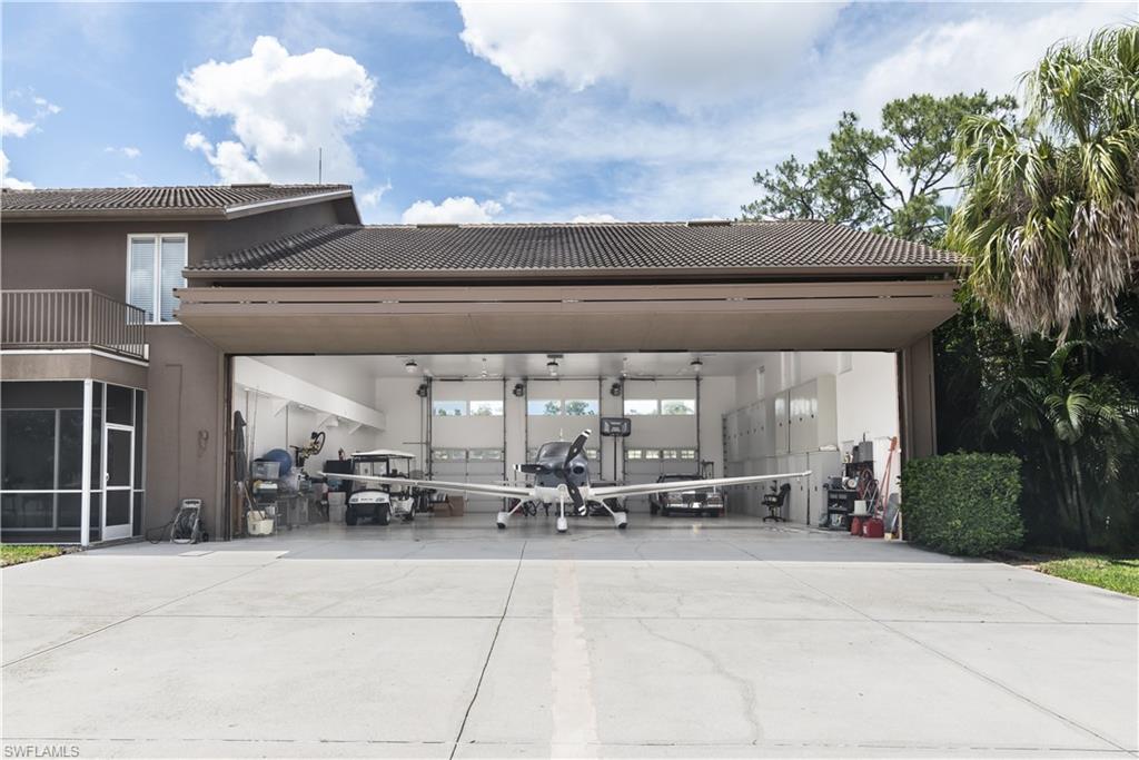 Experience the ultimate combination of luxury living and private aviation in this exceptional two-story hangar h
home, ideally located in Naples, Florida. Just minutes from the area's pristine Gulf beaches and the renowned boutiques, restaurants, and entertainment of 5th Avenue South and 3rd Street South, this one-of-a-kind property offers an unmatched lifestyle. Built in 1993 and thoughtfully updated, the home features an open-concept design highlighted by soaring volume ceilings, custom cabinetry, and granite countertops throughout. With three spacious bedrooms, four full bathrooms, a dedicated 10' x 14' office, and an expansive family room, the floor plan is designed for both everyday comfort and effortless entertaining.Recent improvements include all-new appliances, fresh interior and exterior paint, and updated tile flooring. The luxurious primary suite offers walk-in closets, generous storage, and a whirlpool bidet, creating a private retreat. Upstairs, a versatile loft provides the ideal space for a media room, game room, home office, or additional lounge area. Step outside to enjoy the peaceful screened lanai, perfect for relaxing or entertaining year-round. The oversized three-car garage with integrated hangar provide exceptional space for an airplane, helicopter, motorhome, golf cart, or an impressive automobile collection. Best of all, you don't have to be a pilot to appreciate everything this unique community has to offer. Nestled within an exclusive gated aviation community, ownership includes a 1/59 interest in a private 4,400-foot by 100-foot lighted, paved runway, providing convenient access for aviation enthusiasts. The attached aircraft hangar is equipped with a 42-foot bi-fold door offering 11 feet 6 inches of clearance, making it as functional as it is impressive. Offering approximately 7,000 square feet under roof, this remarkable residence is a rare opportunity to enjoy luxury, privacy, and the freedom of aviation in one of Southwest Florida's most sought-after destinations.