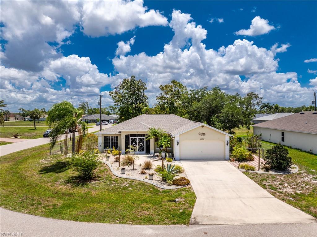 Welcome to 16074 Overdale Court, a lovingly maintained 3-bedroom, 2-bath, 2-car garage home set on a desirable corner lot in the Deed-Restricted community of Burnt Store Village. Residents here enjoy a community park with gazebo, playground, and a scenic walking trail around the lake and public water and sewer. This home features a FULLY RENOVATED KITCHEN, a newer 2021 ROOF, a NEW 2025 AC SYSTEM, a new 2025 DRYER and DISHWASHER. NO FLOOD INSURANCE IS REQUIRED. The heart of this home is the stunning kitchen, beautifully renovated in spring of 2023. Gorgeous quartz countertops, an oversized farmhouse sink, a large breakfast bar with underlighting, glass display cabinets, display shelves with uplighting, and an abundance of storage make this a chef's dream and a natural gathering place for family and friends. The adjacent dining room features attractive window treatments. The spacious great room is sure to impress with its high ceilings, a wall-mounted flat screen TV, and lovely views of the backyard, where a beautiful oak tree provides natural shade. Sliding glass doors open to the generous 10' × 25' tiled screened lanai — perfect for enjoying Florida's outdoor lifestyle — and an additional open patio beyond. The fully fenced yard is perfect for your pup. This home's designer coastal color palette, modern dark bronze fans and fixtures, and tile flooring throughout the main living areas give the interior a polished, cohesive feel. The smart split-bedroom floor plan ensures privacy for everyone. The primary suite is generously sized with an accent wall, windows on two sides, a seating area, walk-in closet, and linen closet. The ensuite bath features a single vanity with a dedicated dressing table. The guest wing is accessed through a modern barn door — ideal for morning privacy — and includes two spacious bedrooms, each comfortably accommodating queen beds with bifold door closets. The guest bath offers a tub/shower combination with sliding glass door and single vanity. Step outside and enjoy the curb appeal: a wide paver entry sidewalk, curated plantings, concrete-curbed flower beds with stone mulch, and a paver patio. The screened front entry leads to a welcoming foyer with a coat closet and a handy alcove for hats and leashes. The laundry room off the kitchen offers great space and storage shelving. Peace of mind comes standard — this home has full hurricane protection on all windows and doors, including impact sliding glass doors and an impact-rated front entry door. Major updates include a new roof (2021), full kitchen renovation (2023), new refrigerator (2023), new A/C (winter 2025), new dishwasher (2025), and new dryer (2025). Low utility bills round out the picture. This is Florida living at its finest — move-in ready, thoughtfully updated, and priced to sell.