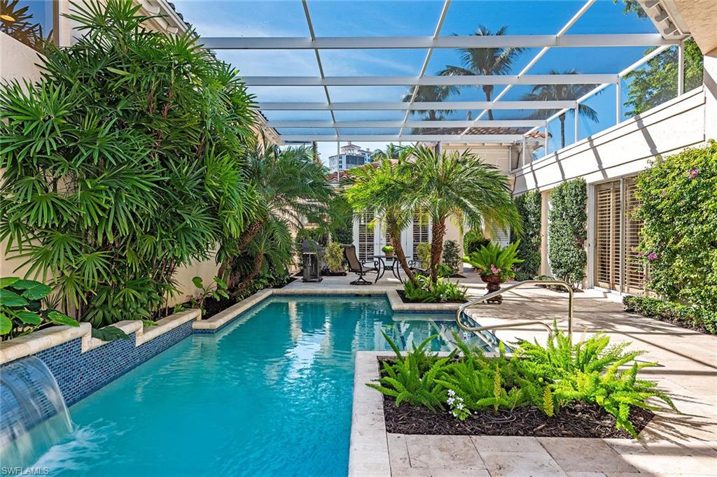 Island time. Remodeled and remastered to spacious, light and bright open concept living spaces, this private courtyard villa welcomes you into a lushly landscaped, tropical and sunny, screened pool courtyard. Offering long lake views, desired long driveway and unique additional side courtyard. The separate guest house opens to spacious lap pool with waterfall wall. Open kitchen with spacious island boasts upscale appliances including induction cooktop. CocoBay offers the sought-after location only a short stroll across the boulevard to the beach tram station and berm walk to Pelican Bay’s private beach and restaurants. Resort-style beach attendants offer resident members and guests chair and umbrella services, while restaurant and bar service await beachside. Enjoy all Pelican Bay amenities in this private gated community.